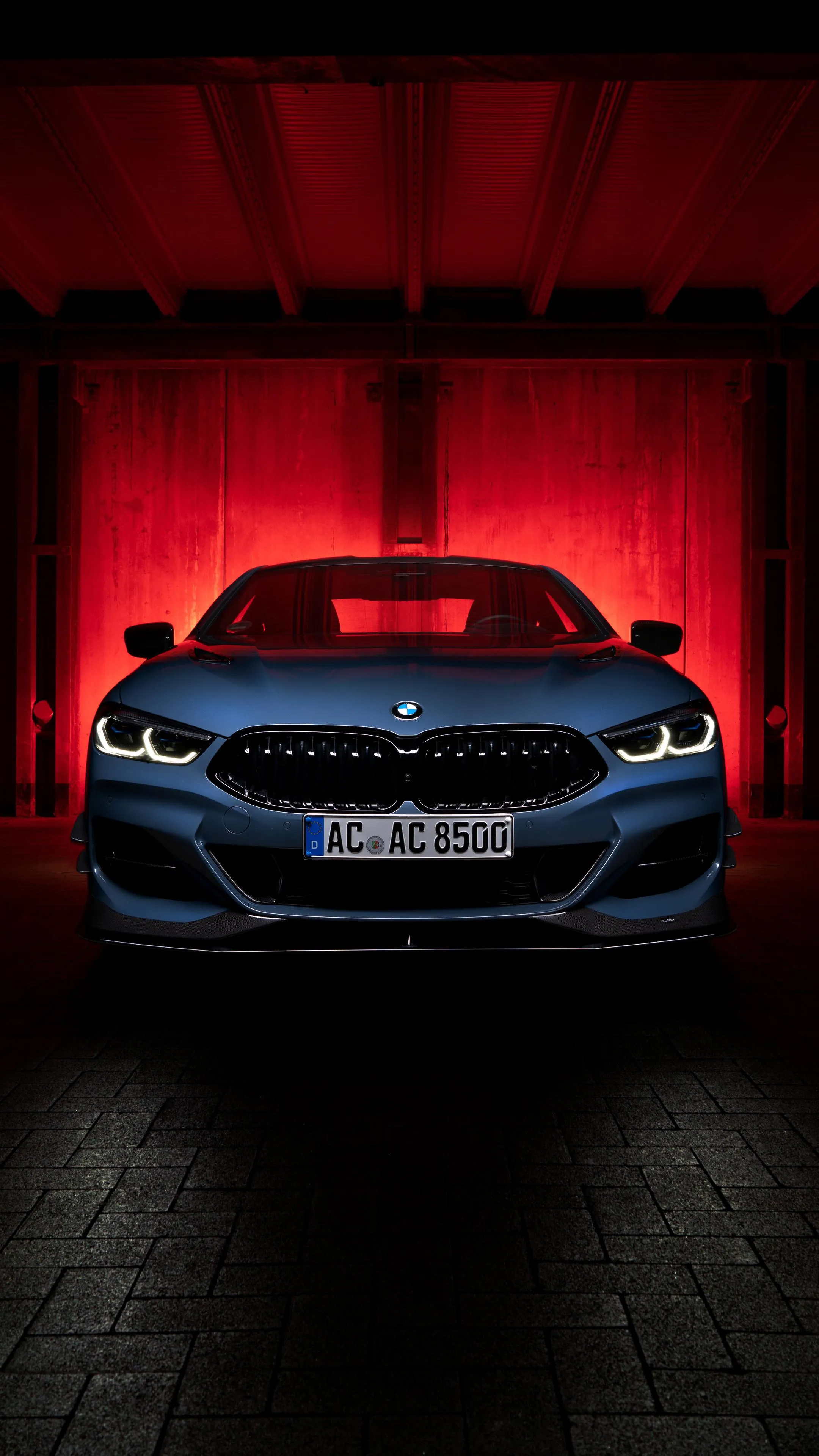 Red Lit Bmw Parked Indoors Creating a Dramatic Shadow Look