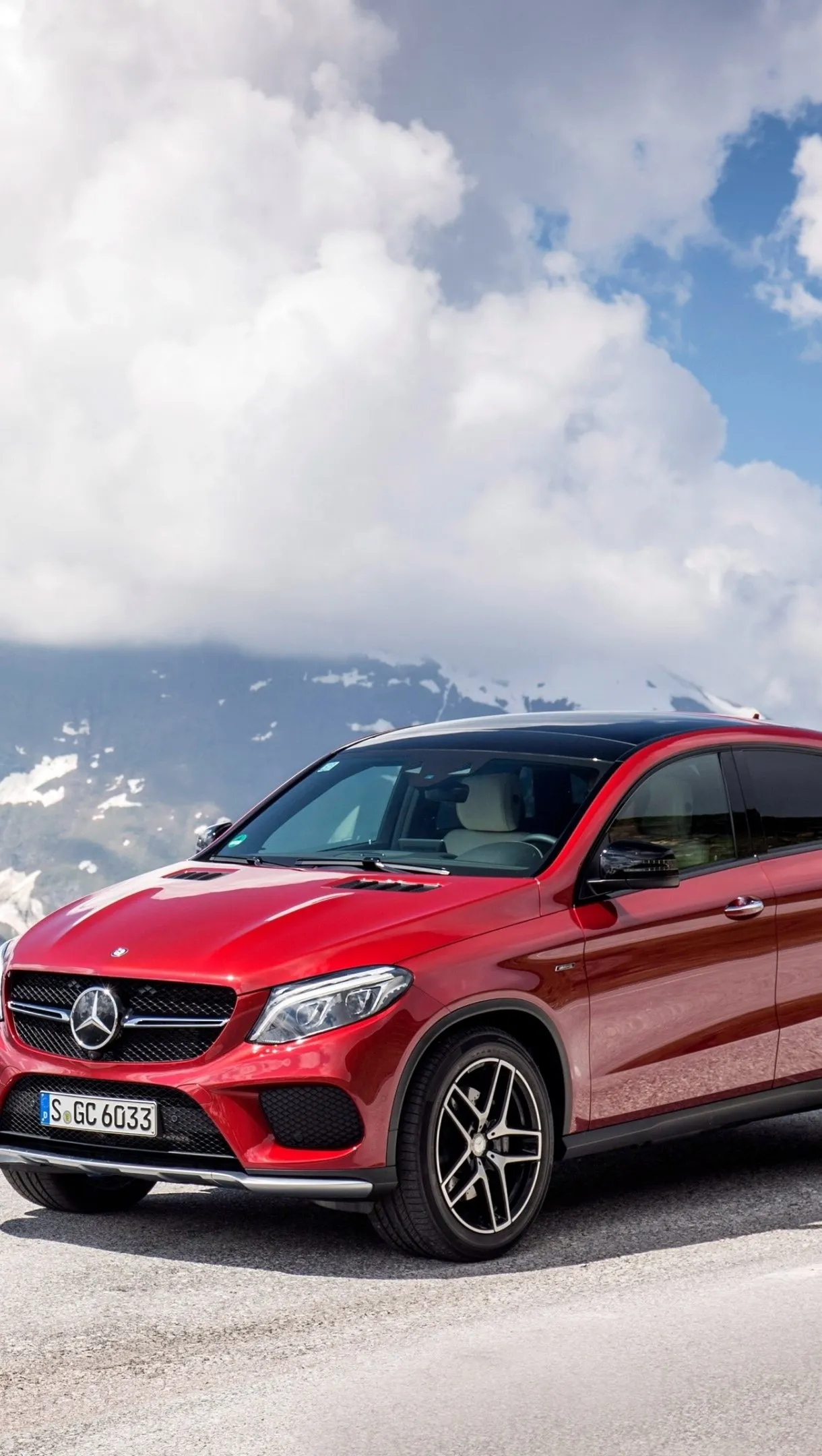 Red Mercedes Benz compact SUV parked near a building