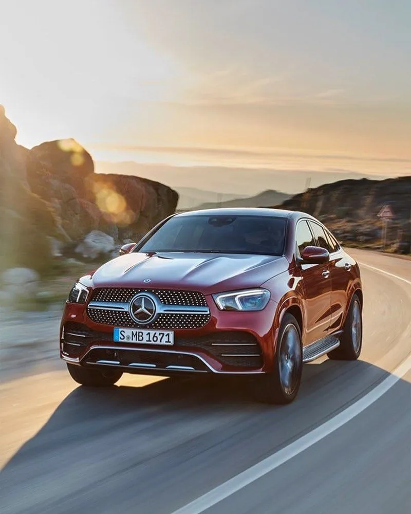 Red Mercedes SUV Driving Through Rocky Desert free image