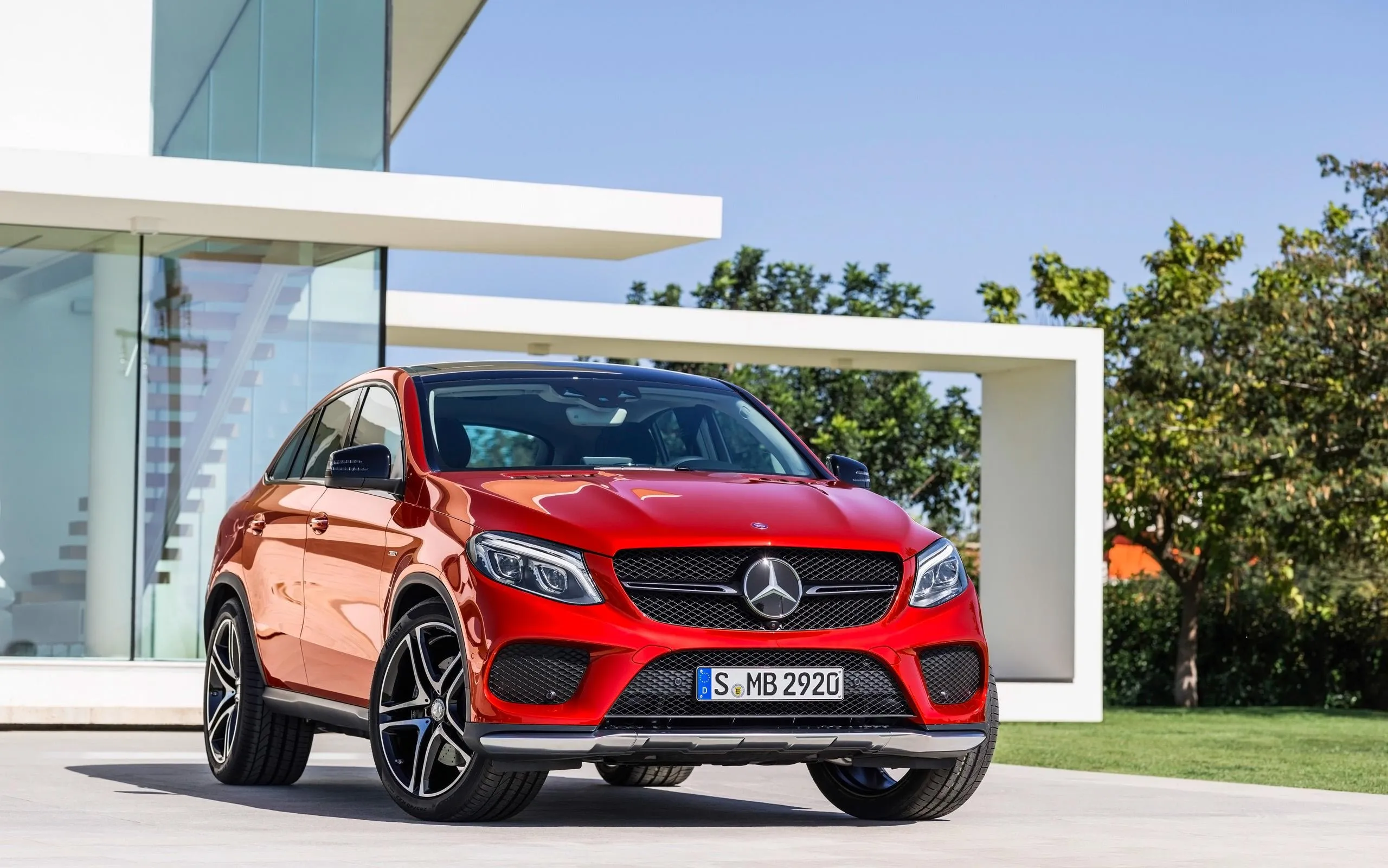 Red Mercedes SUV Parked Near Modern House Exterior Wallpaper