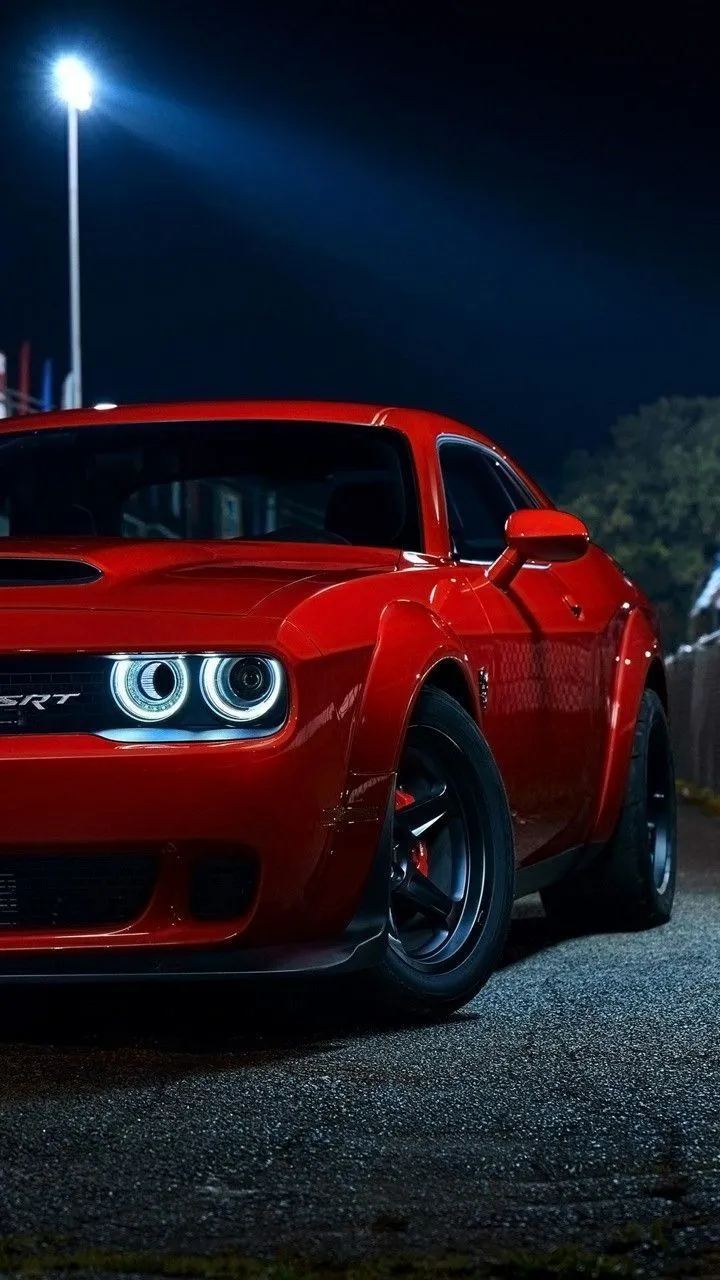 Red Muscle Car Parked at Night With Strong Headlights
