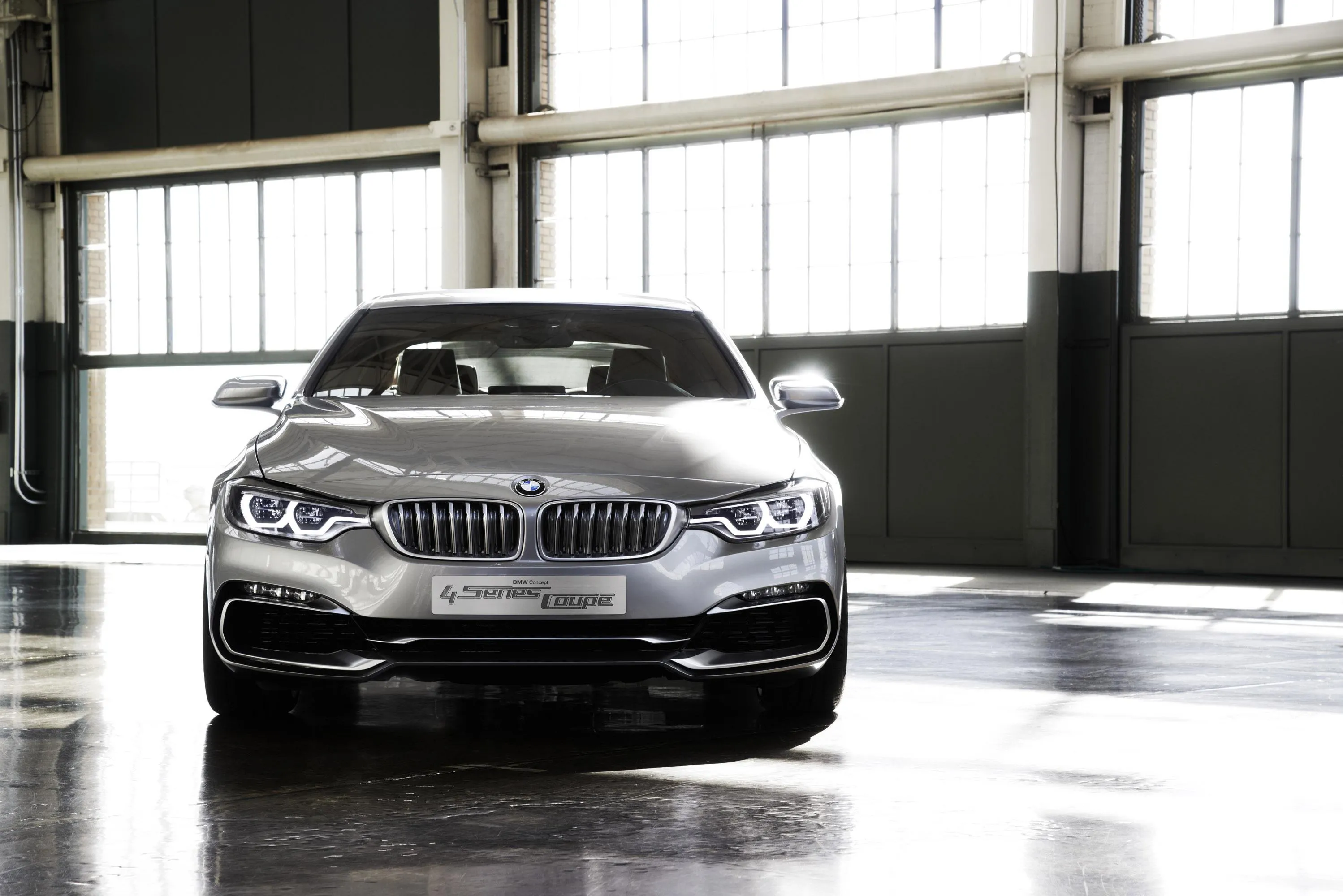 Shiny Silver Bmw Sedan in Modern Indoor Showroom Wallpaper