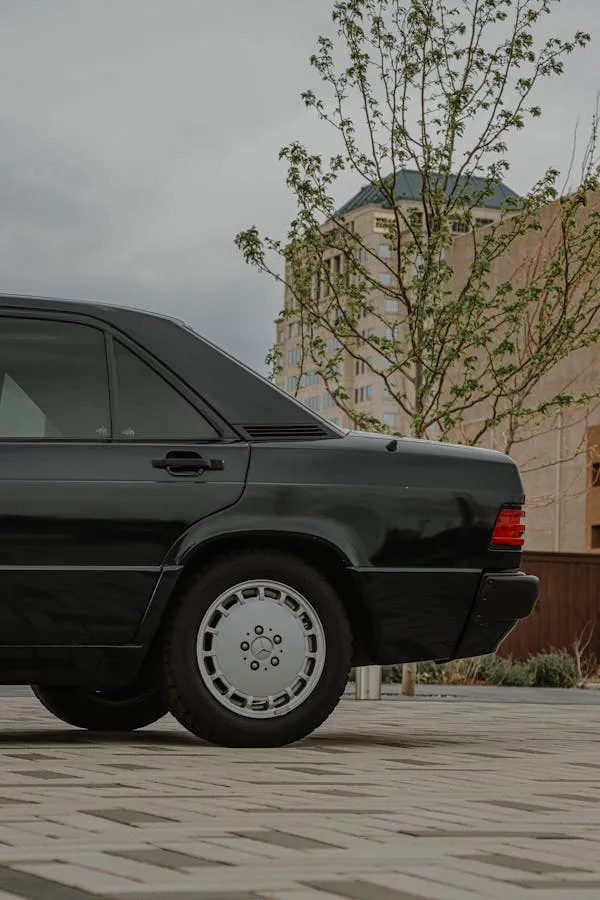 Side View of Black Vintage Benz by City Buildings image