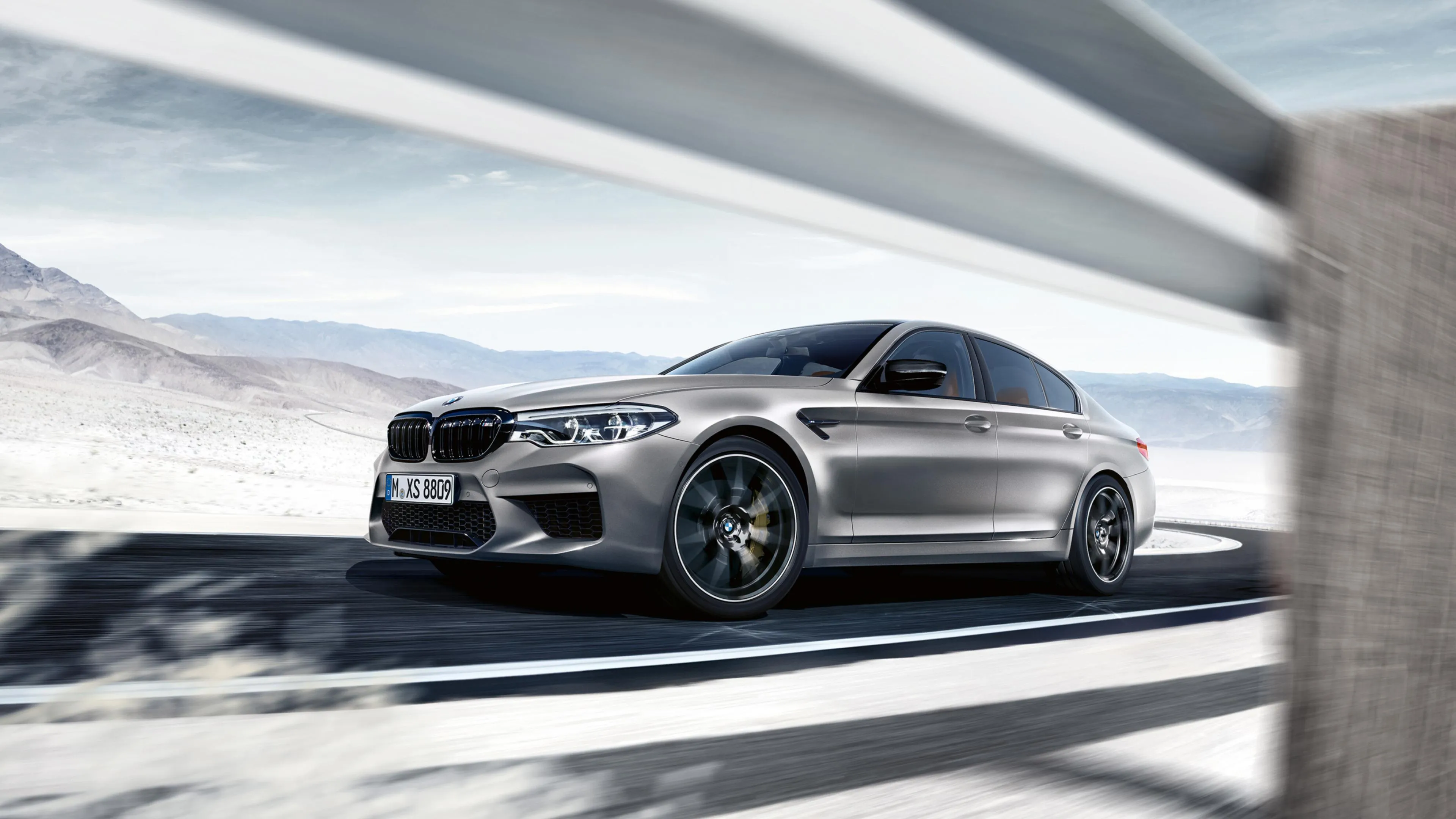Silver Bmw Drifting on a Snowy Mountain Road Wallpaper