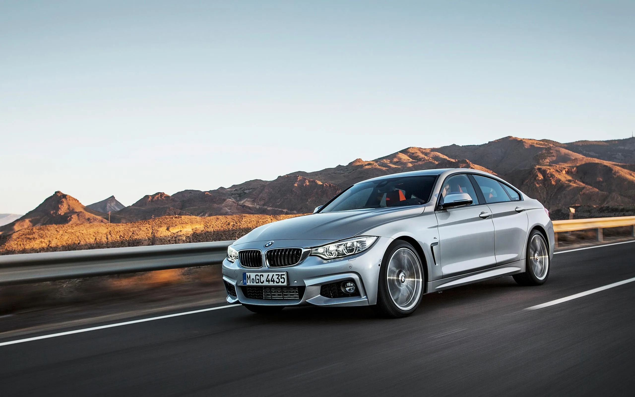 Silver Bmw Driving Along Desert Road in Daylight Image