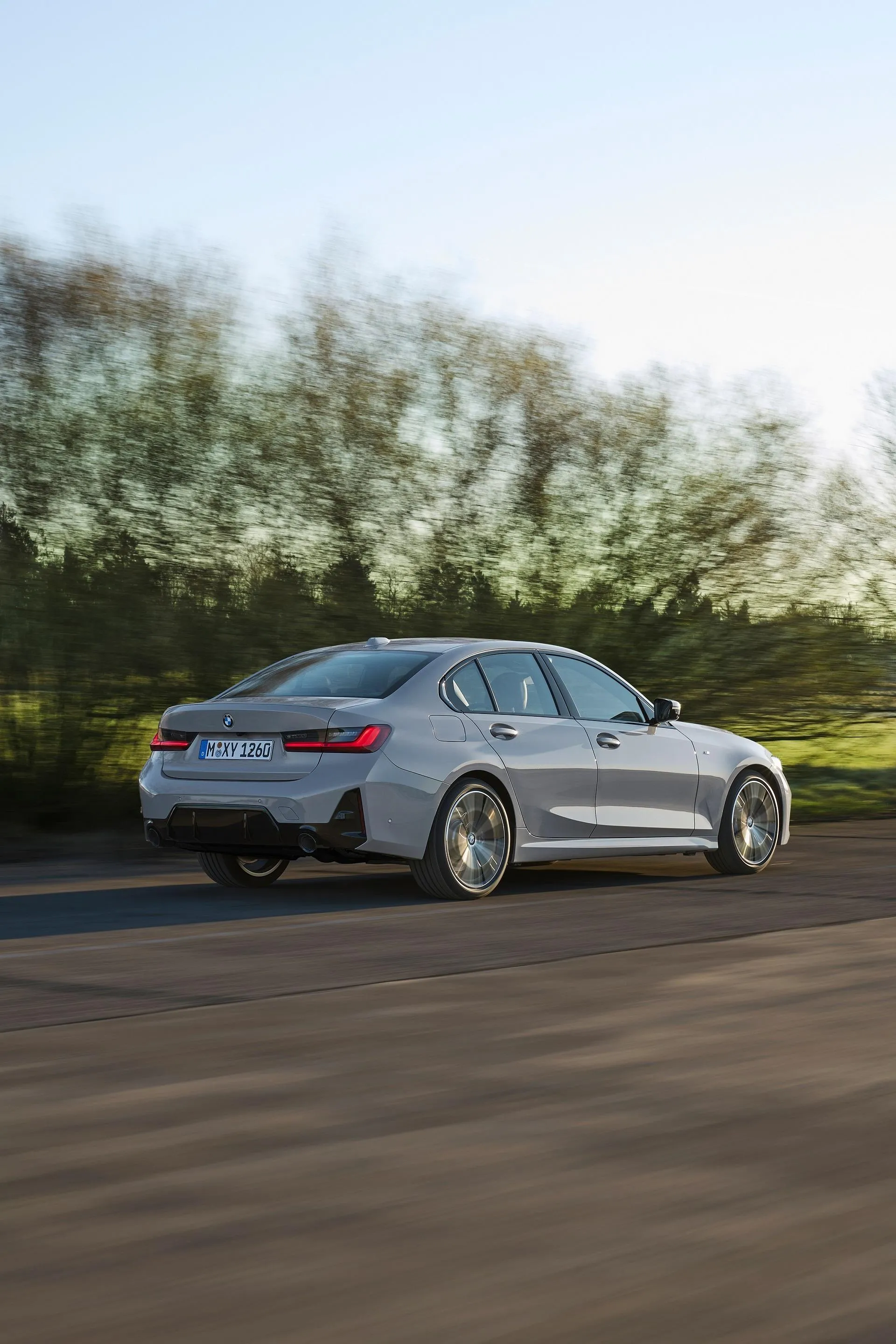 Silver Bmw Sedan Driving Fast Along a Forest Road Wallpaper