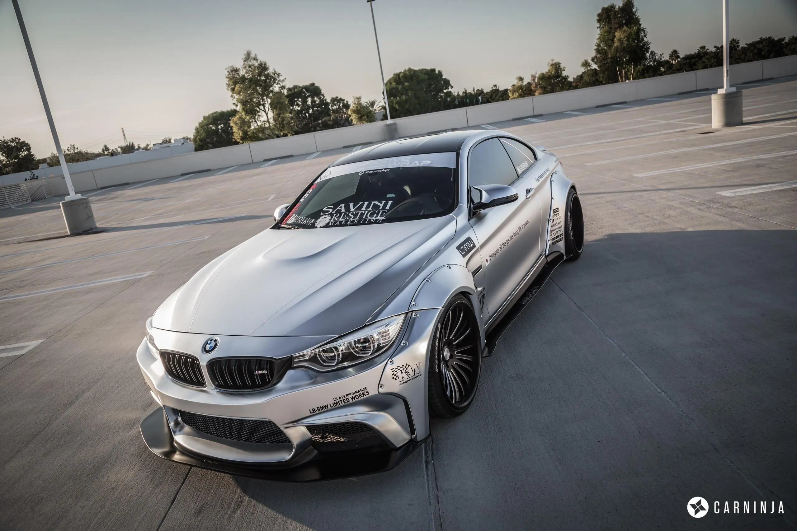 Silver Bmw Sedan Parked on Empty Asphalt Lot Wallpaper