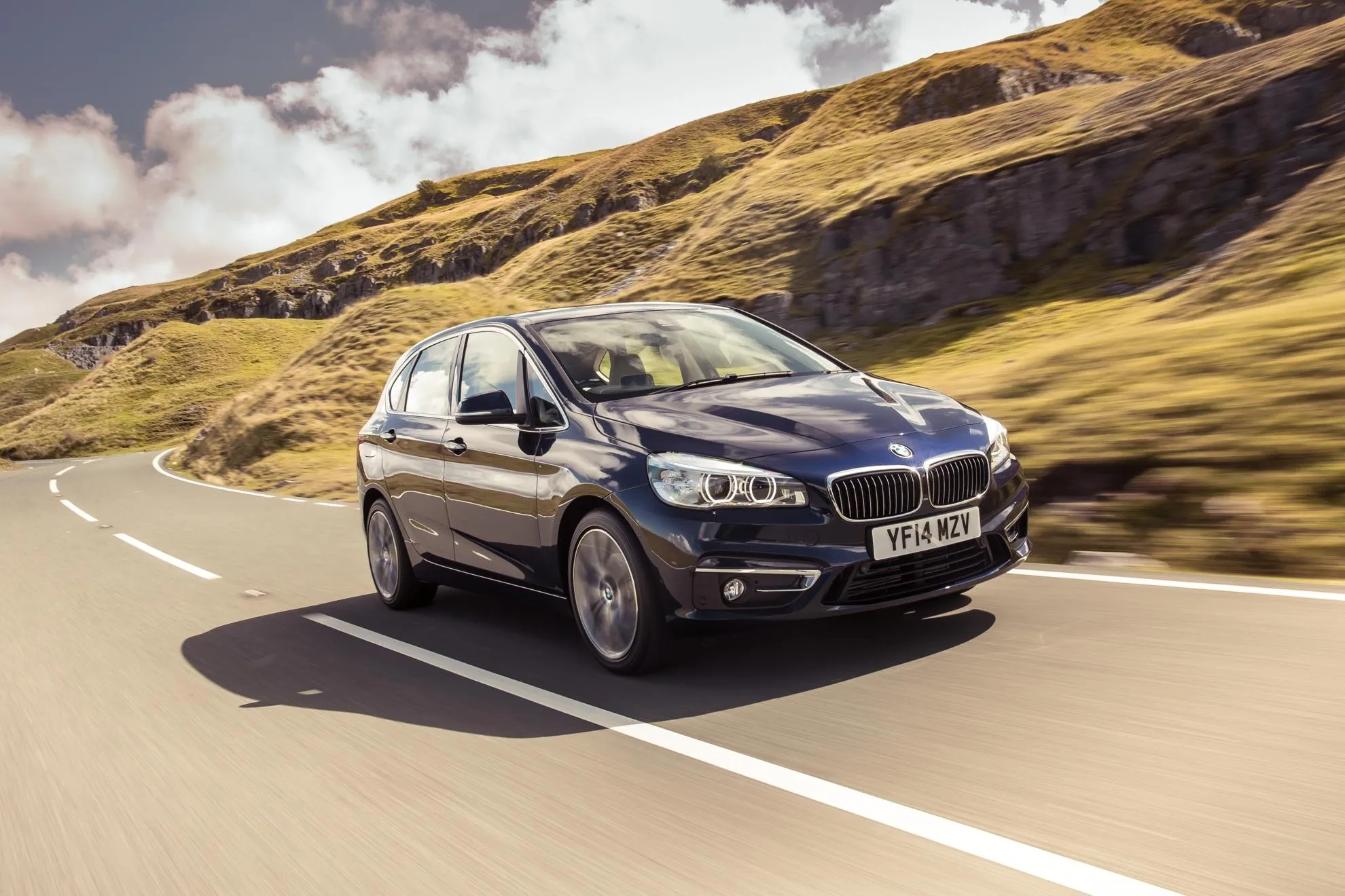 Silver Bmw Sedan Turning on a Curve in a Mountain Area