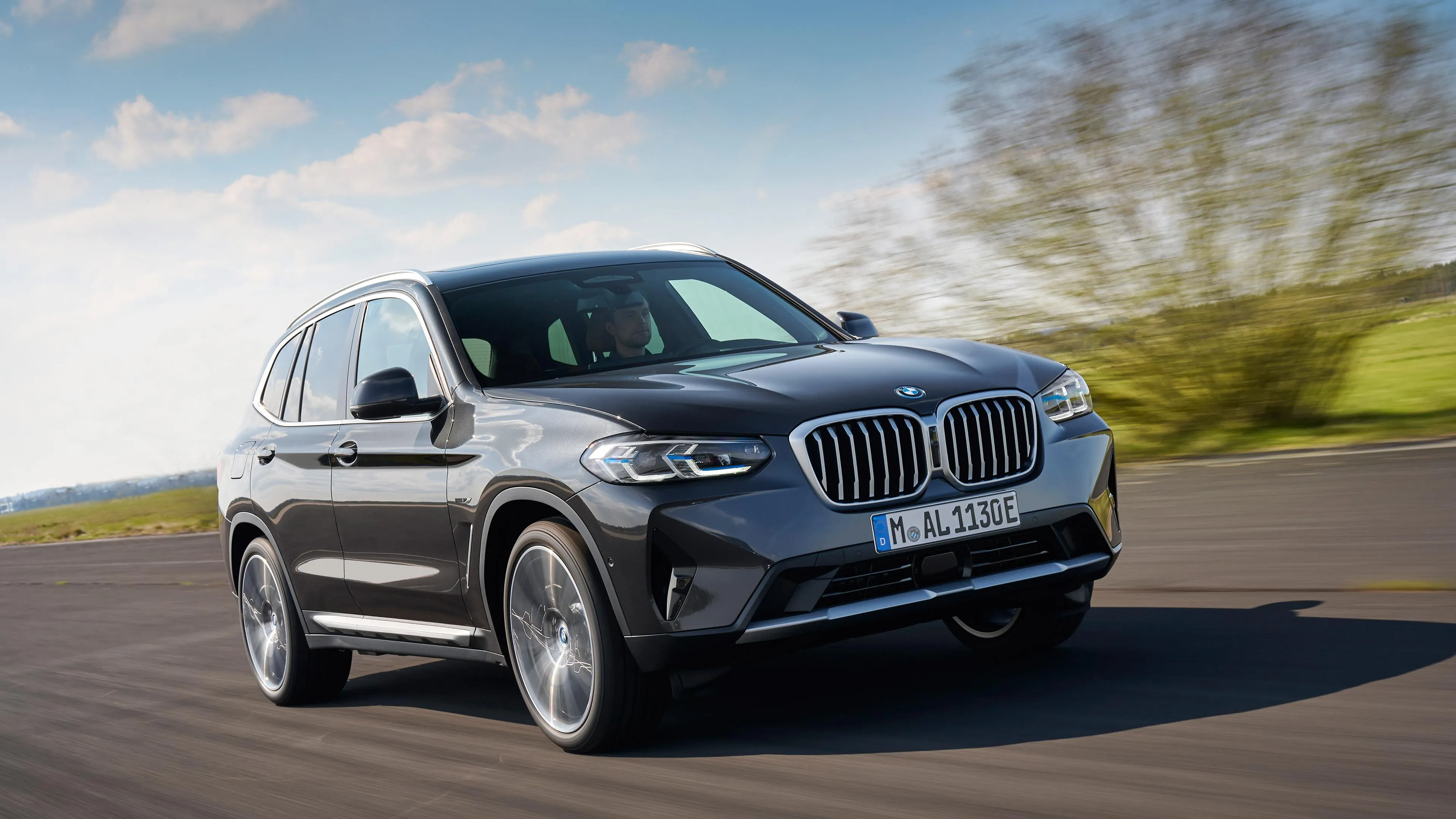 Silver Bmw Suv Driving Through Countryside Road Wallpaper