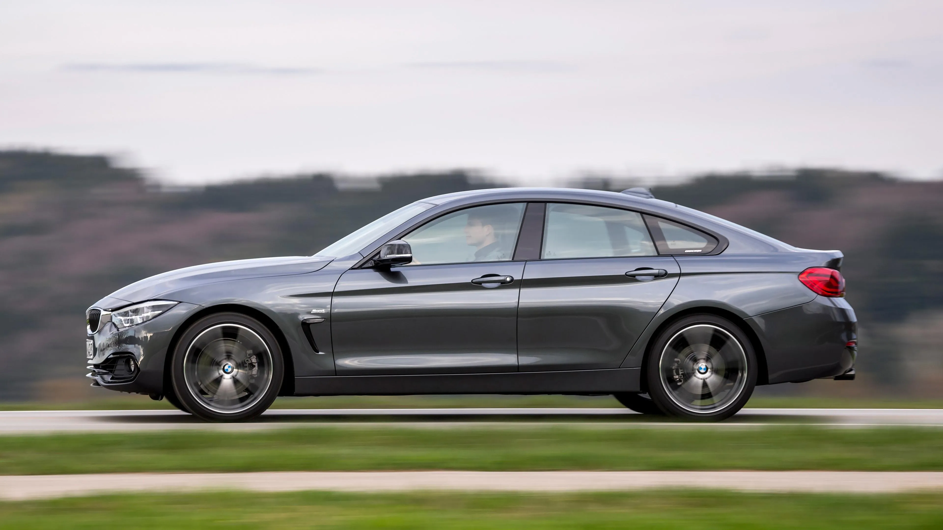 Silver Bmw Suv Parked on Green Grass with Hills in the Back