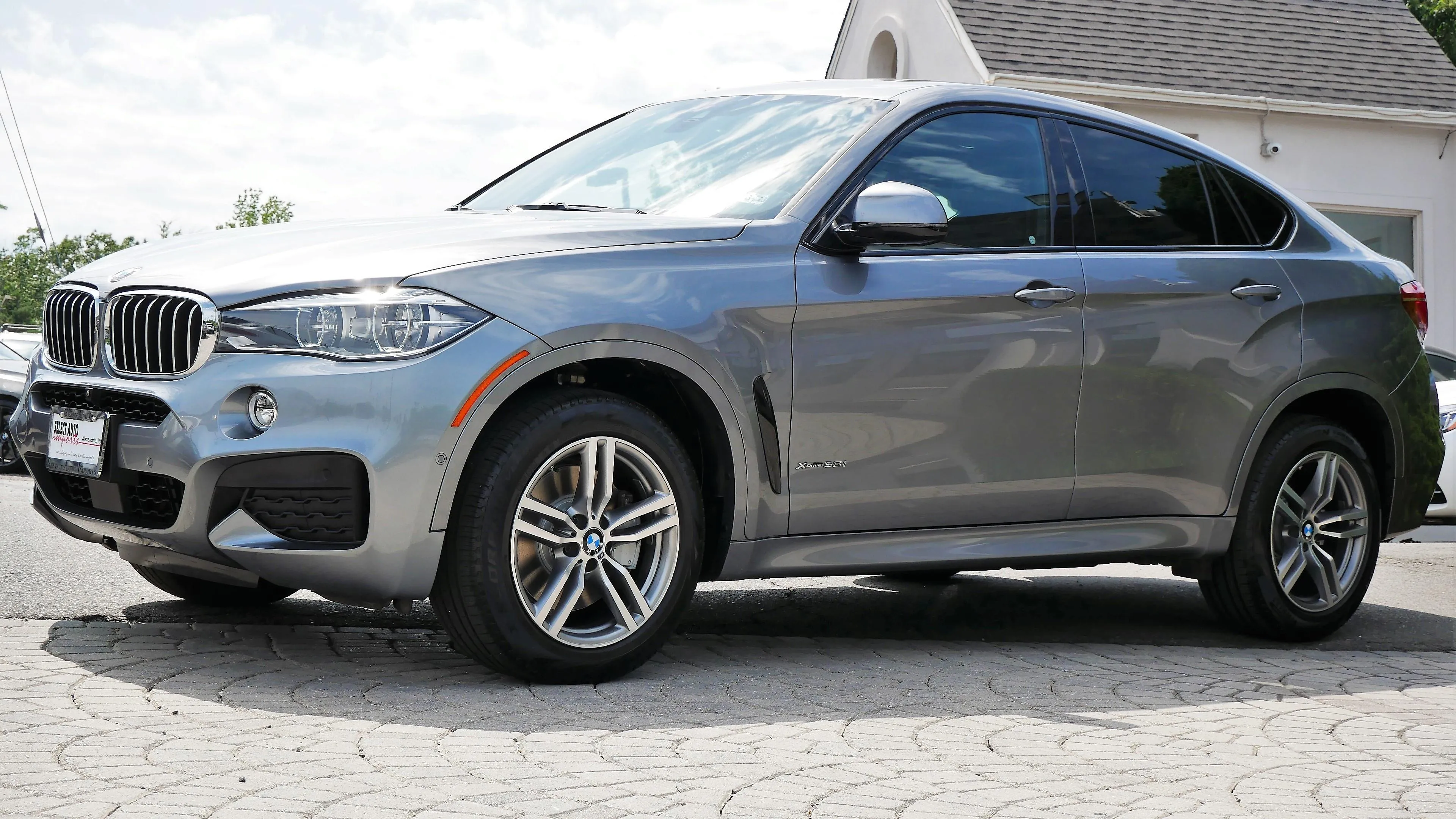 Silver Bmw Suv Parked on Paved Driveway in Sunlight