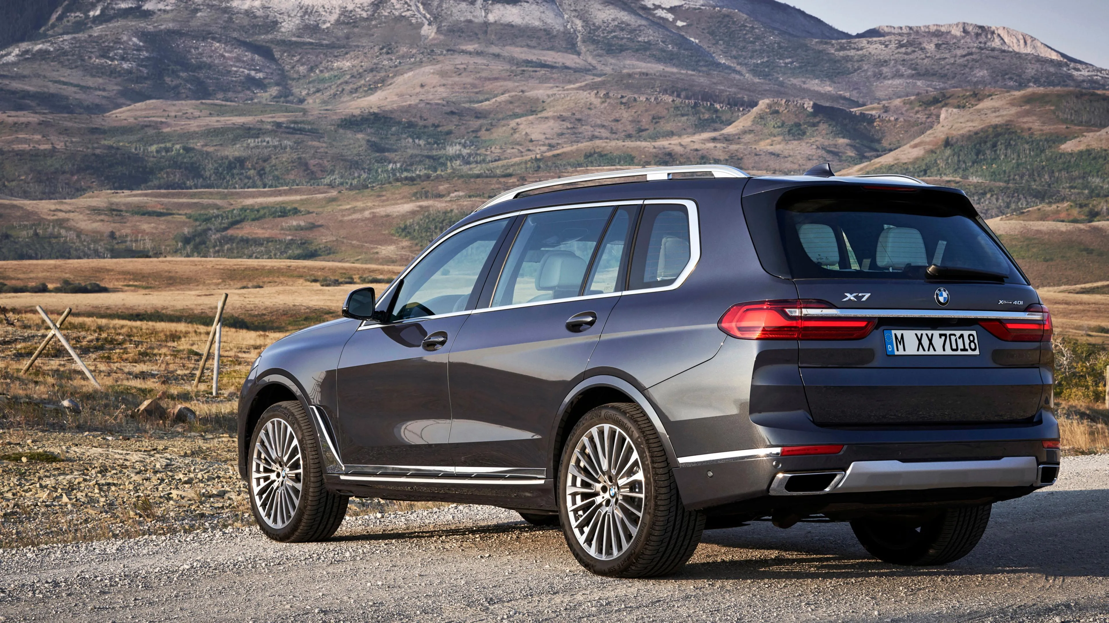 Silver Bmw Suv Parked Roadside with Mountains in Background