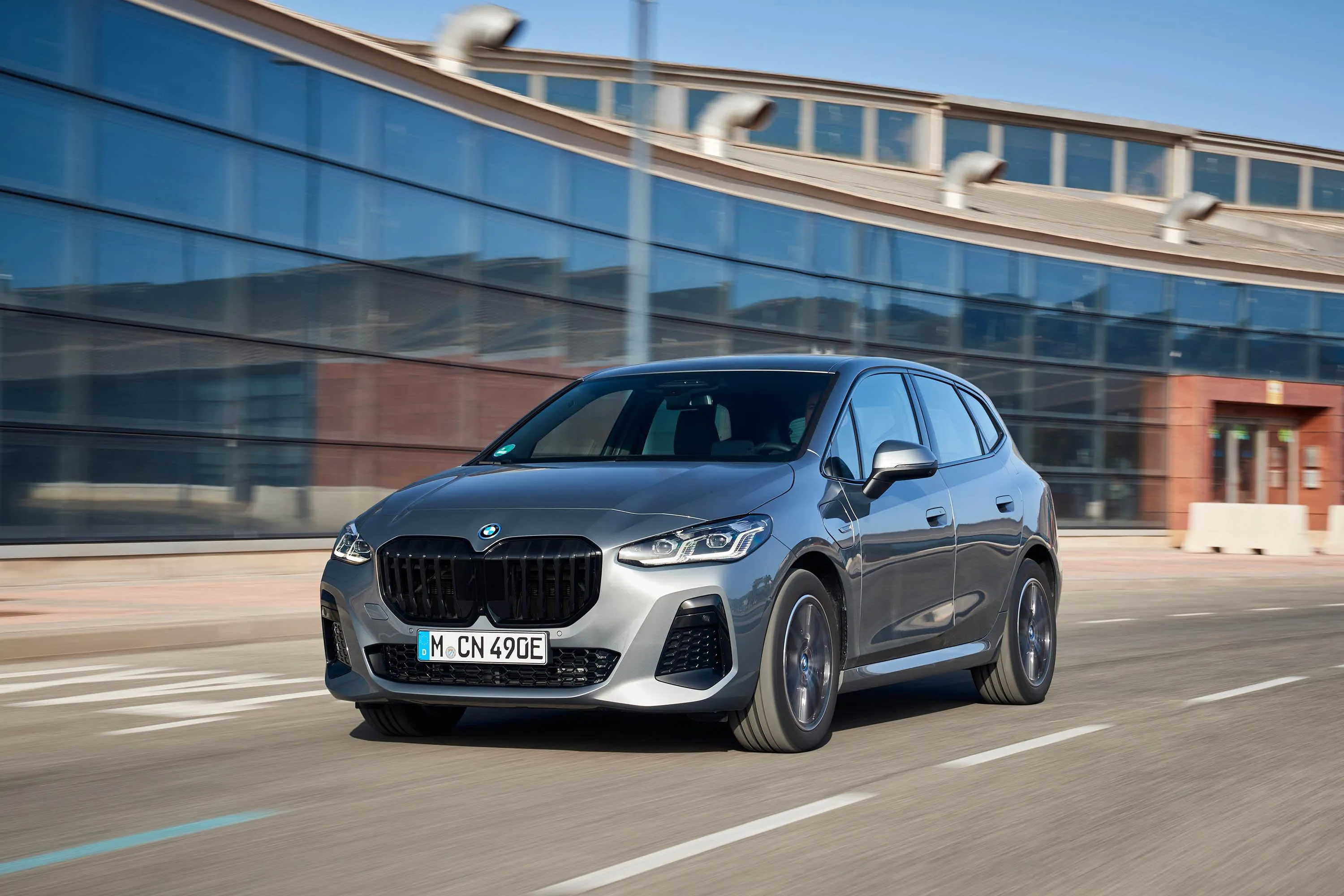 Silver Bmw Suv Passing By Modern Glass Building Wallpaper