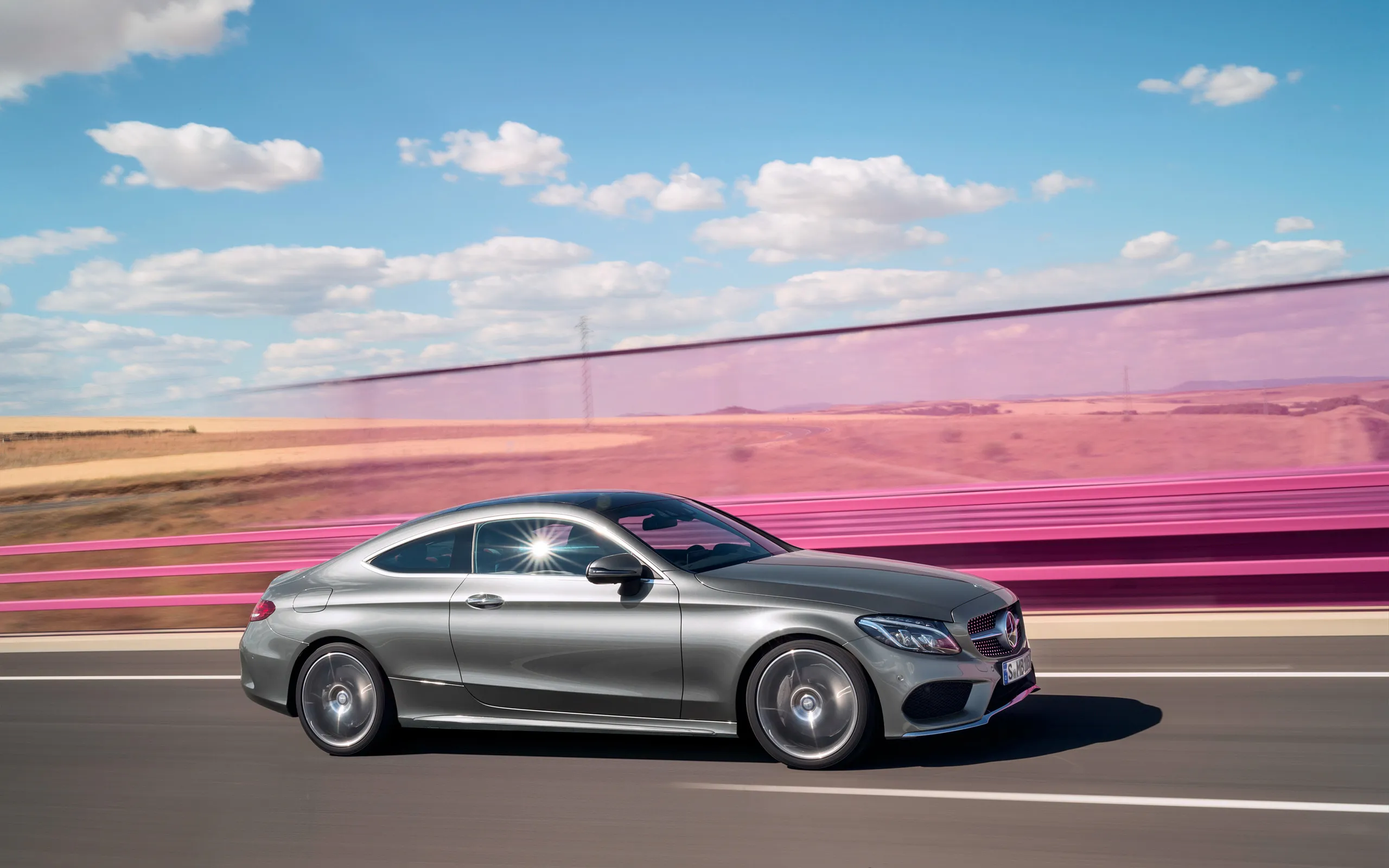 Silver Mercedes Benz Coupe Driving on Vibrant Track image