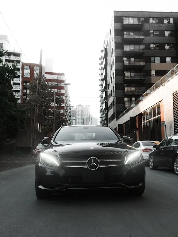Silver Mercedes Benz on Road Between Tall Buildings 4K