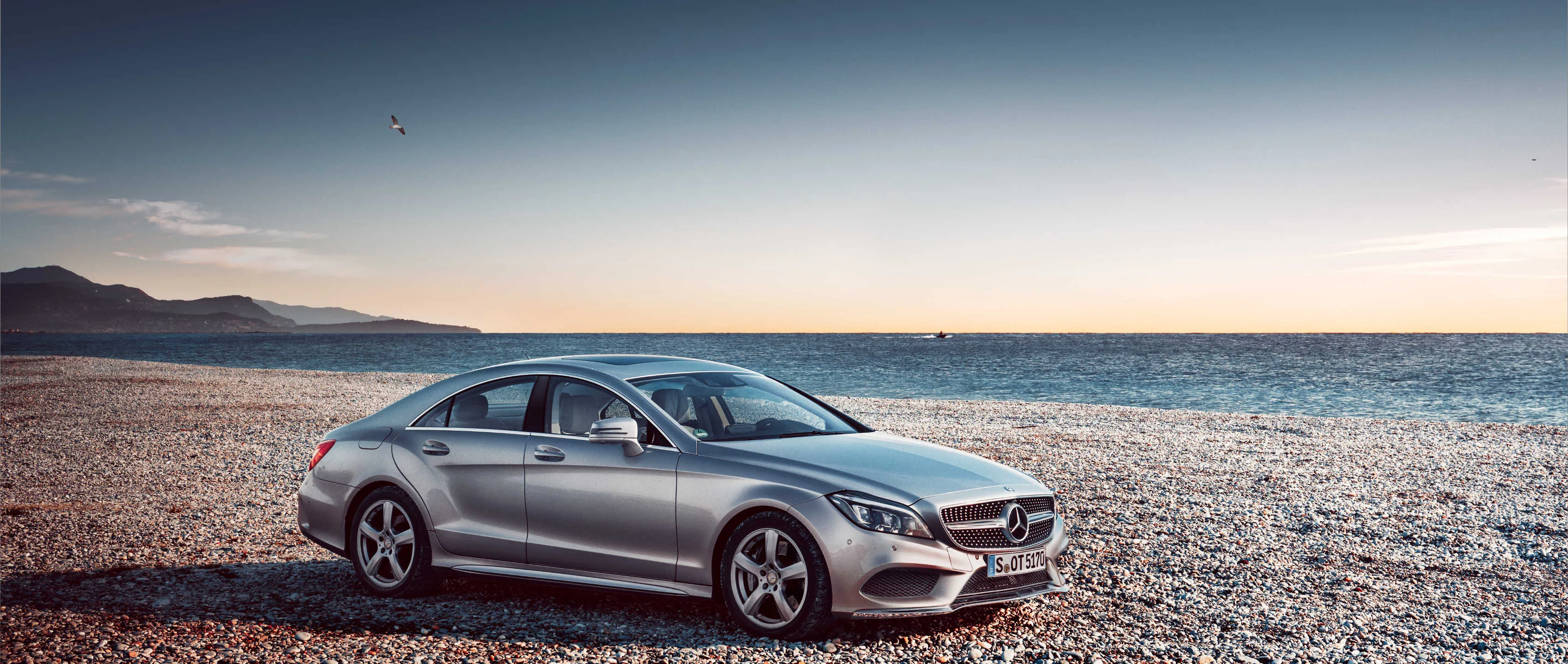 Silver Mercedes Benz on Rocky Coast at Dusk HD Wallpaper