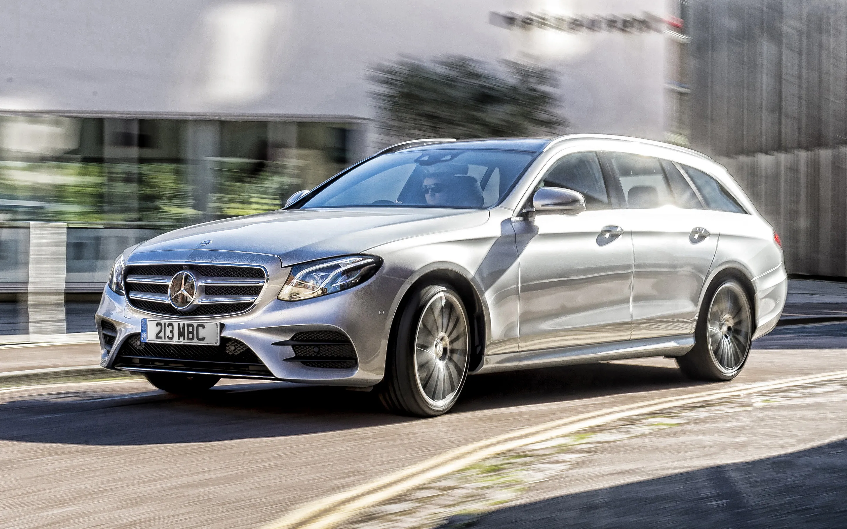 Silver Mercedes Benz Sedan Driving on City Street Wallpaper