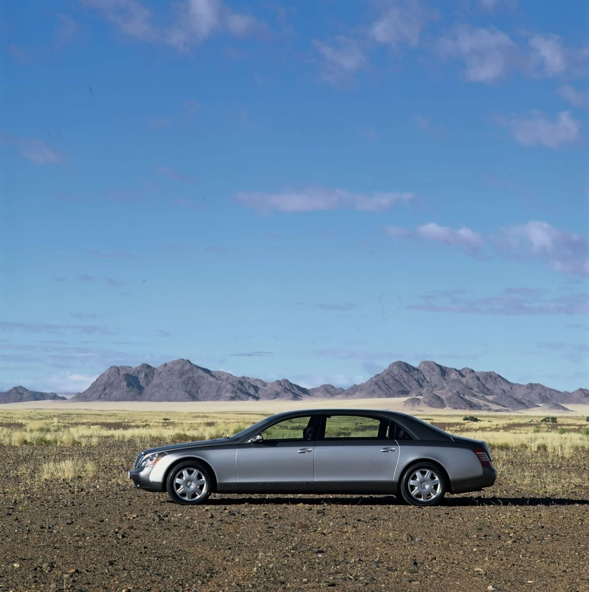 Silver Mercedes Luxury Sedan on Desert Road Wallpaper