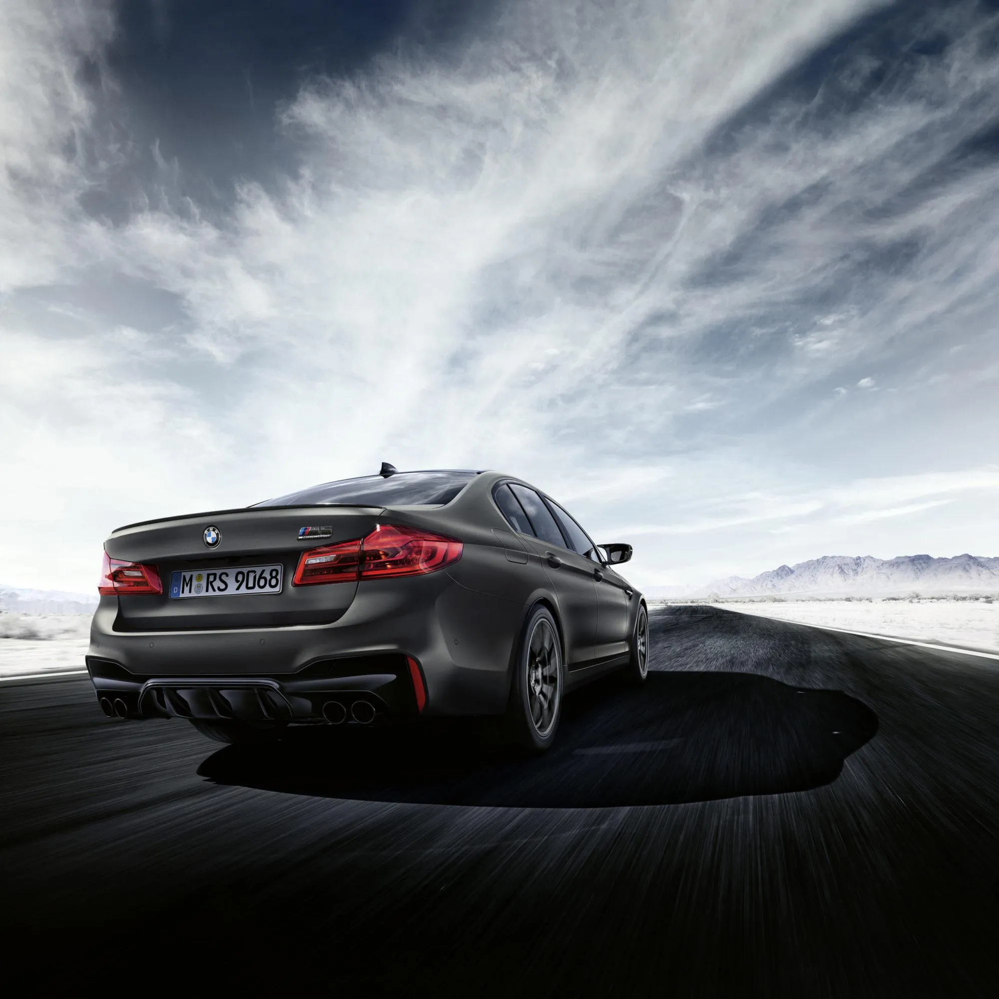 Sleek Black Bmw Coupe Driving on a Mountain Road Image