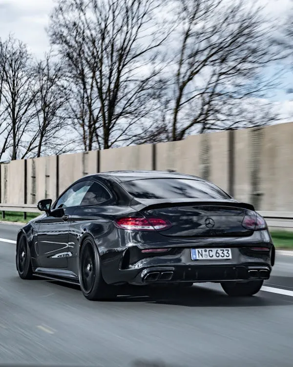 Sleek Black Mercedes Benz Coupe Driving on Highway image