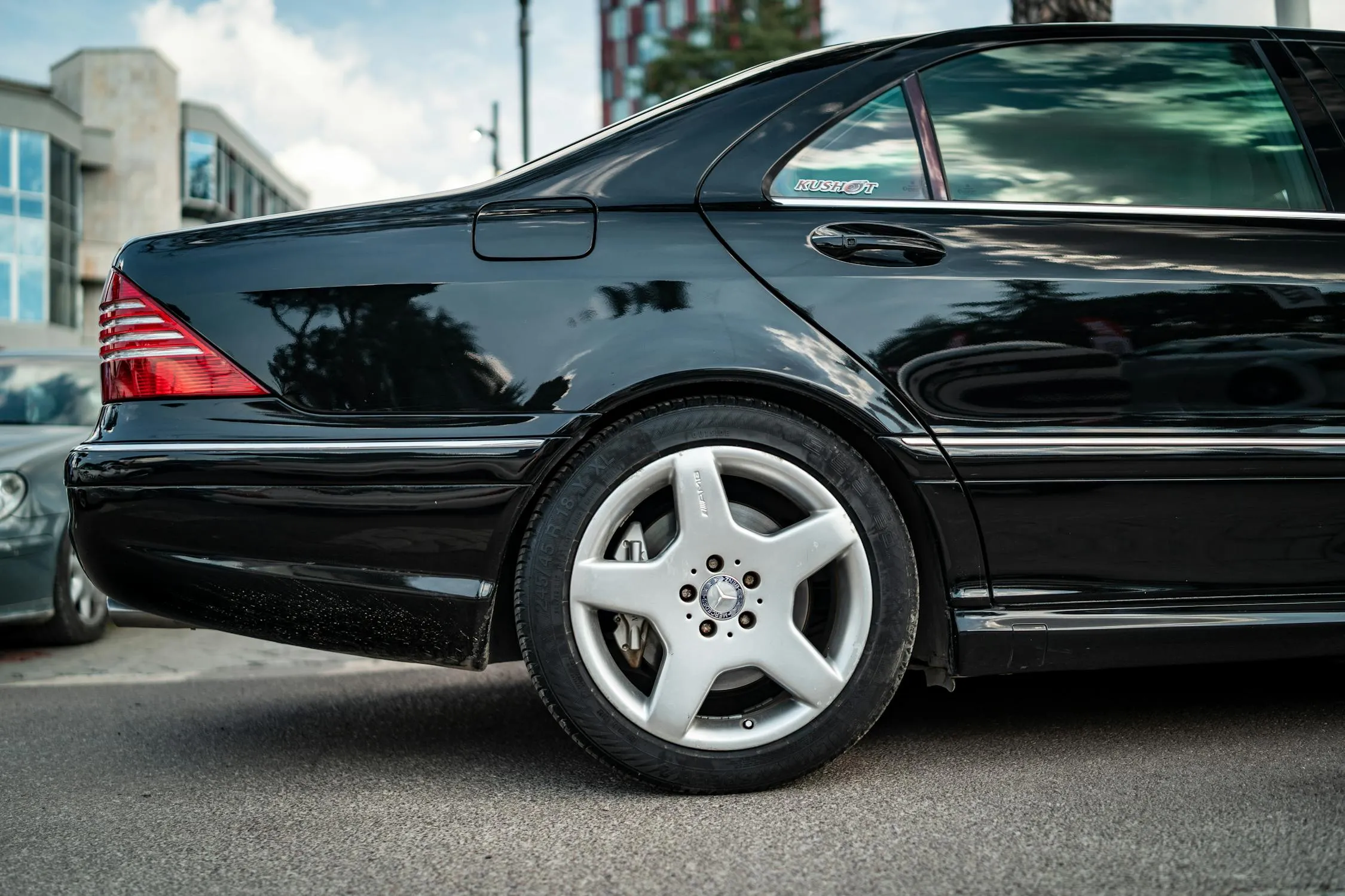 Sleek Black Mercedes Rear View in City Street Wallpaper