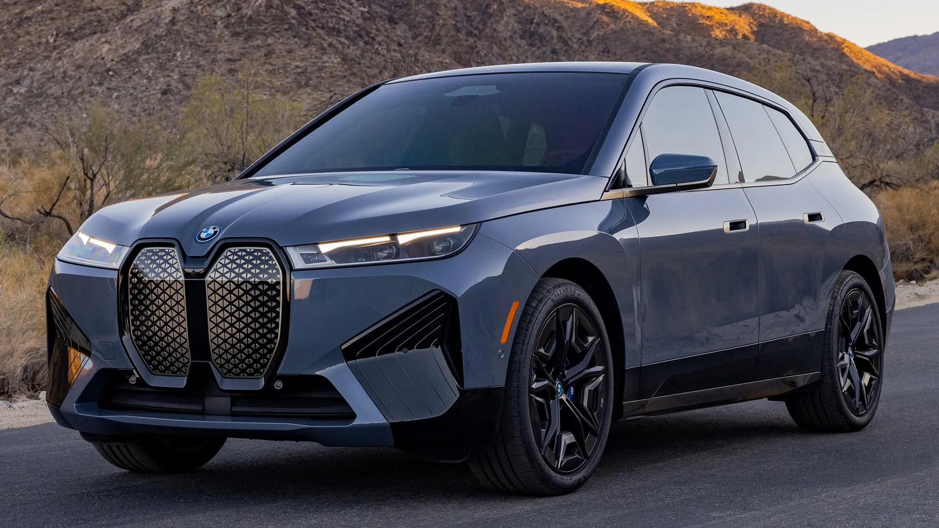 Sleek Gray Bmw Suv Driving Through Scenic Mountain Road
