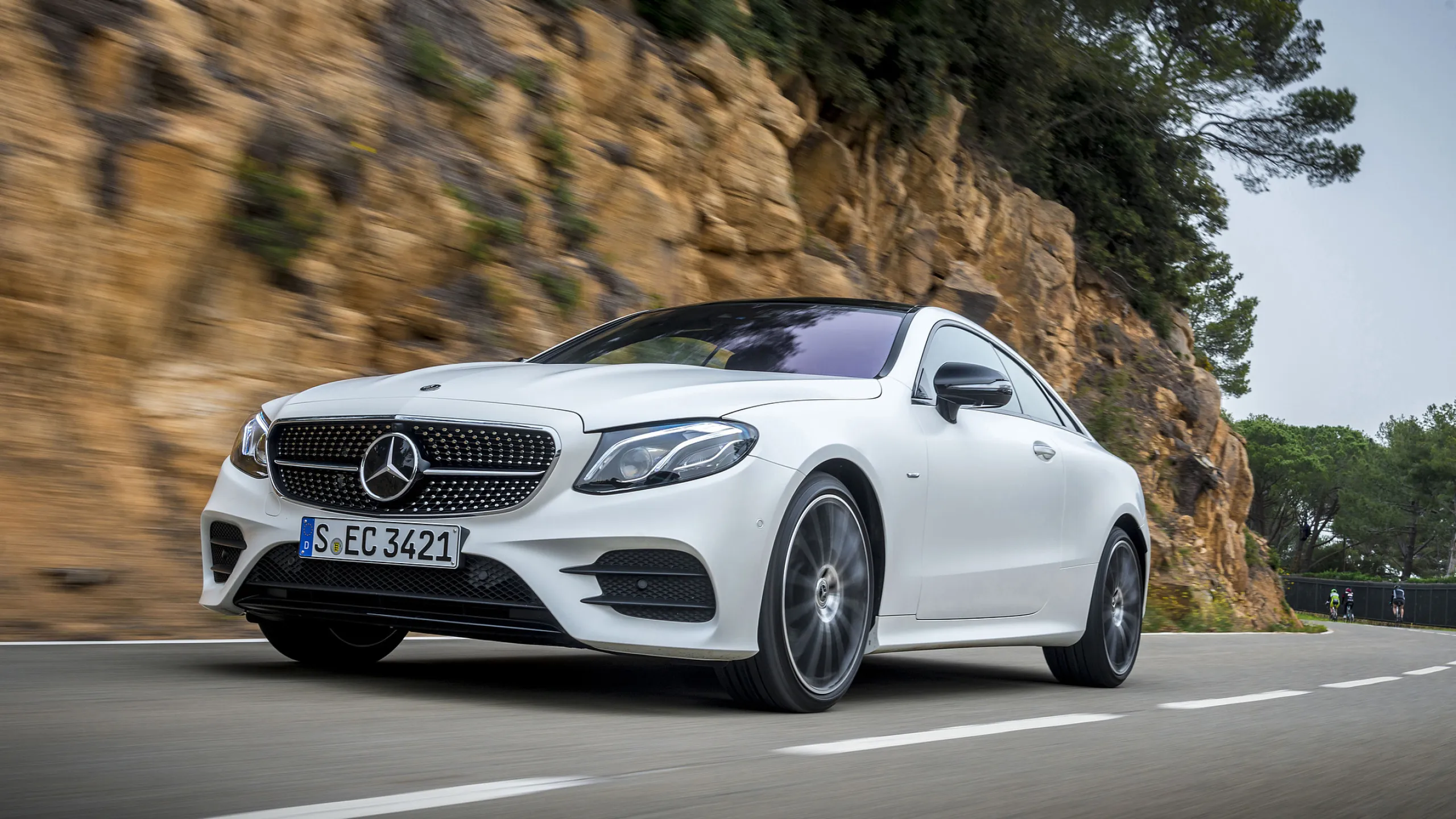 Sleek Mercedes Coupe Gliding Through Serene Forest Road