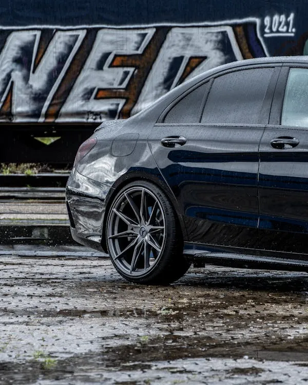 Sleek Mercedes sports sedan parked in urban wet lot