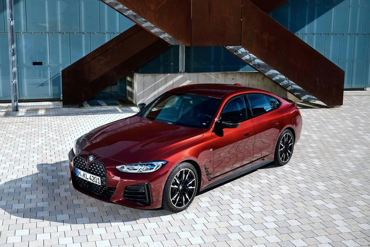 Sleek Red Bmw Parked Under Large Steel Structure Image