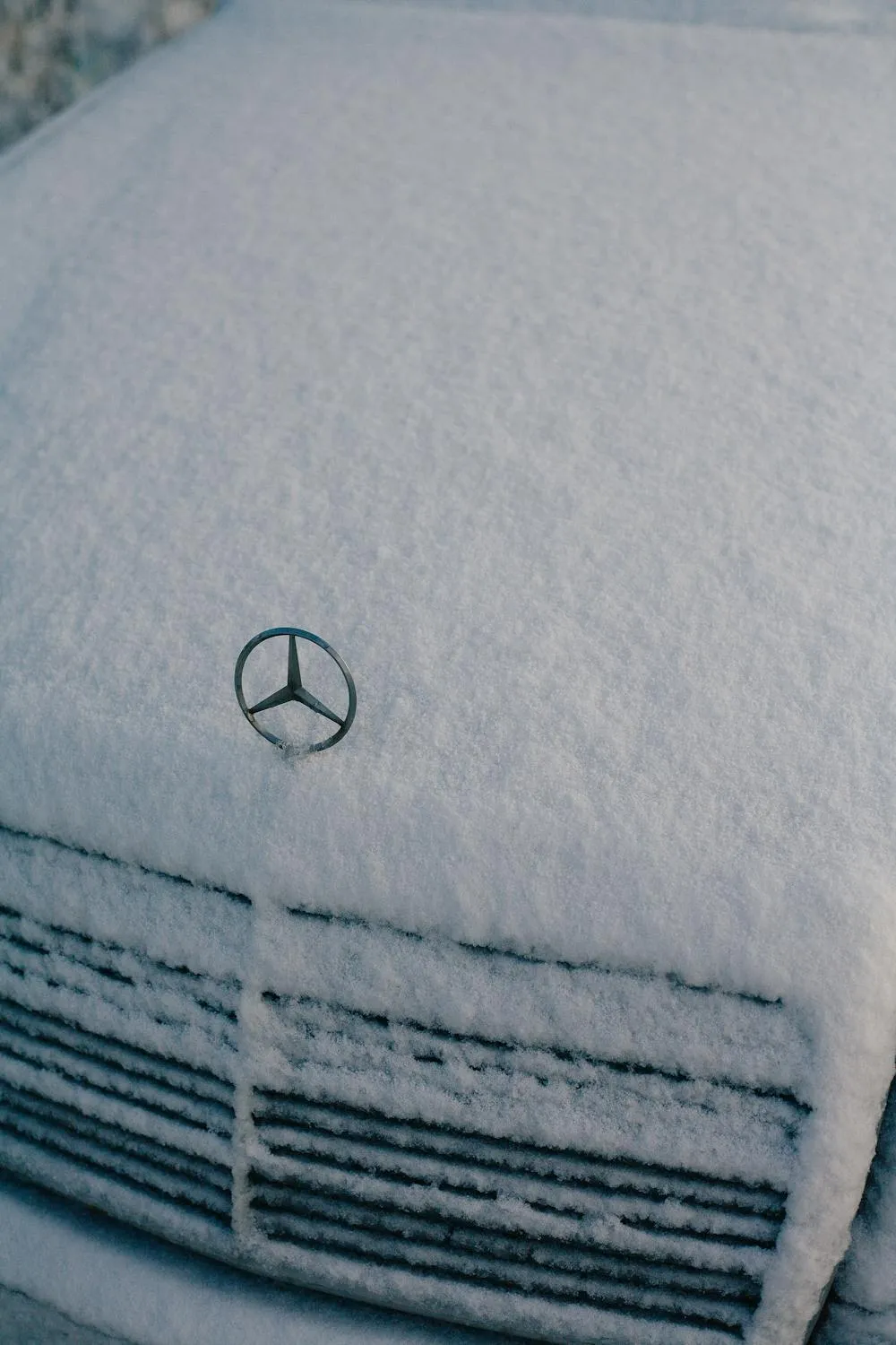 Snow Covered Mercedes Hood with Visible Logo Wallpaper