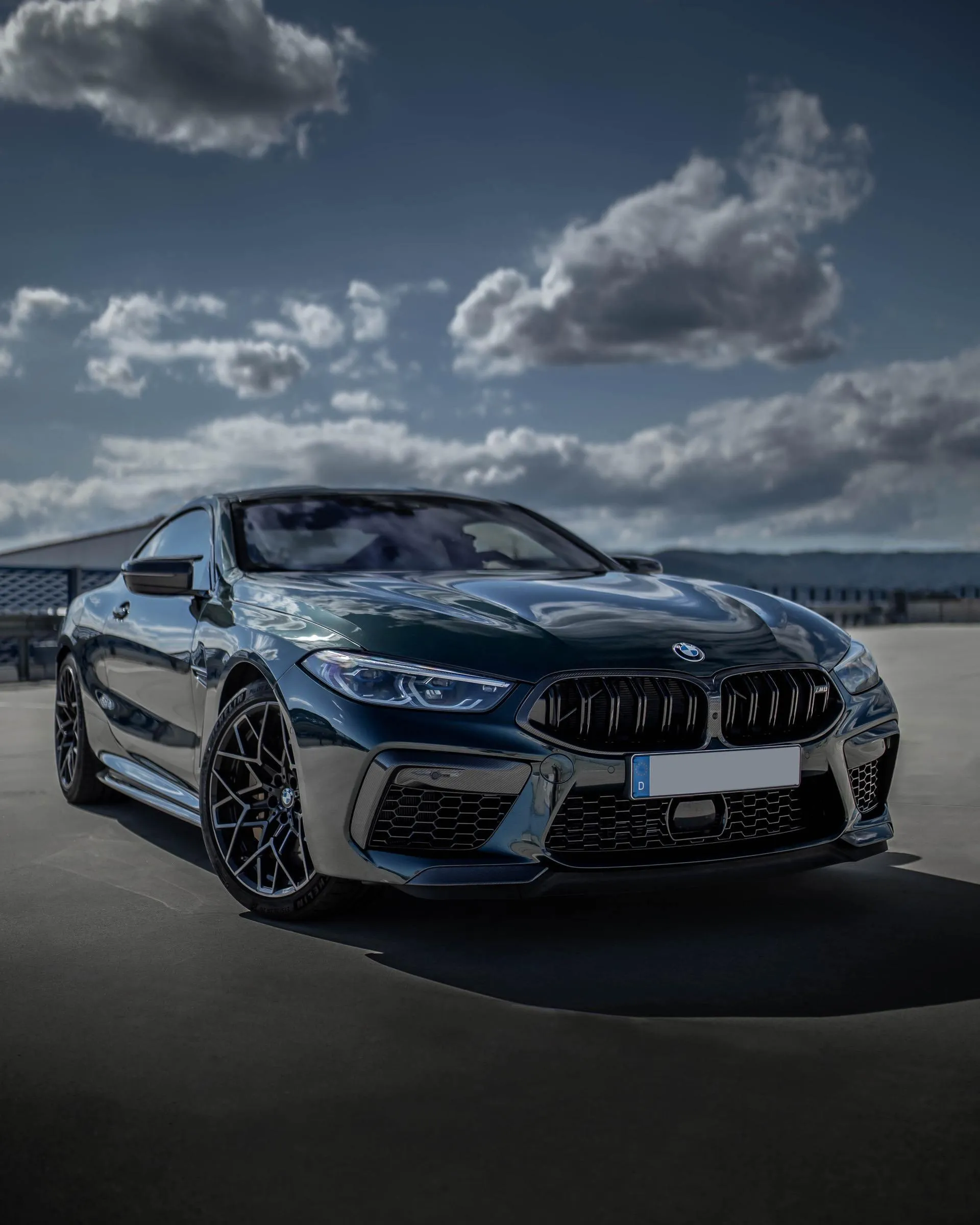 Sporty Bmw M8 with Racing Stripes on Ocean Side Road