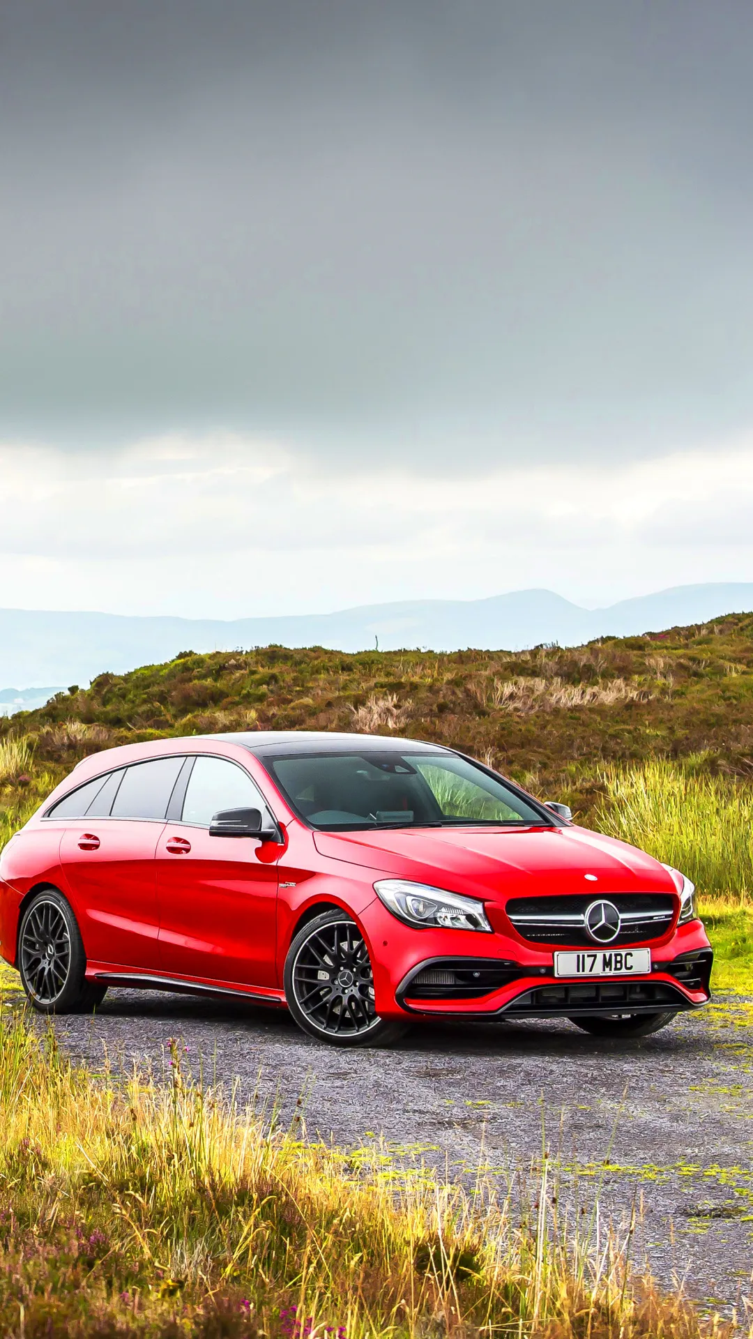Sporty Red Mercedes on Grassy Countryside Road Wallpaper