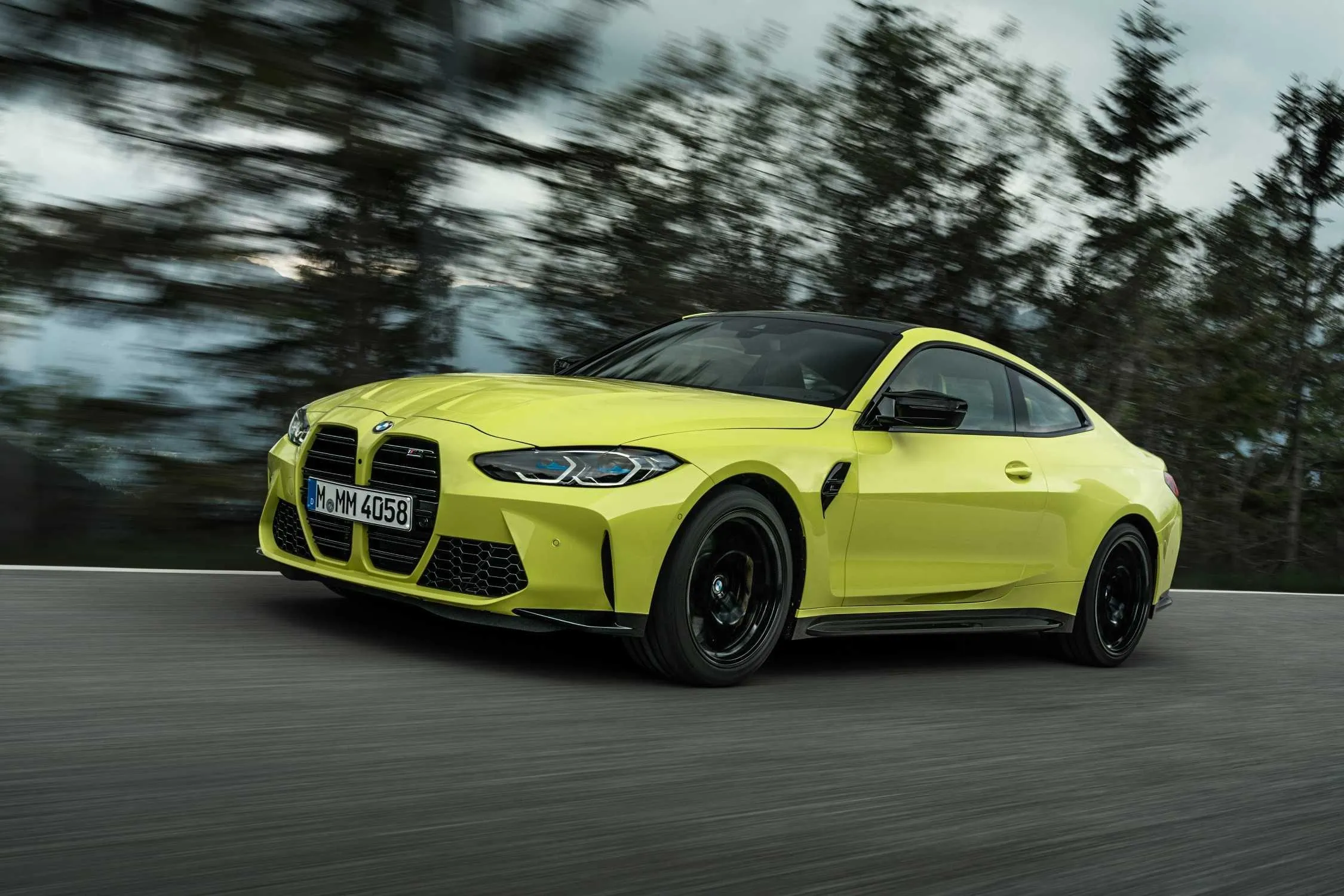 Sporty Yellow Bmw Driving Fast on a Forest Highway Image