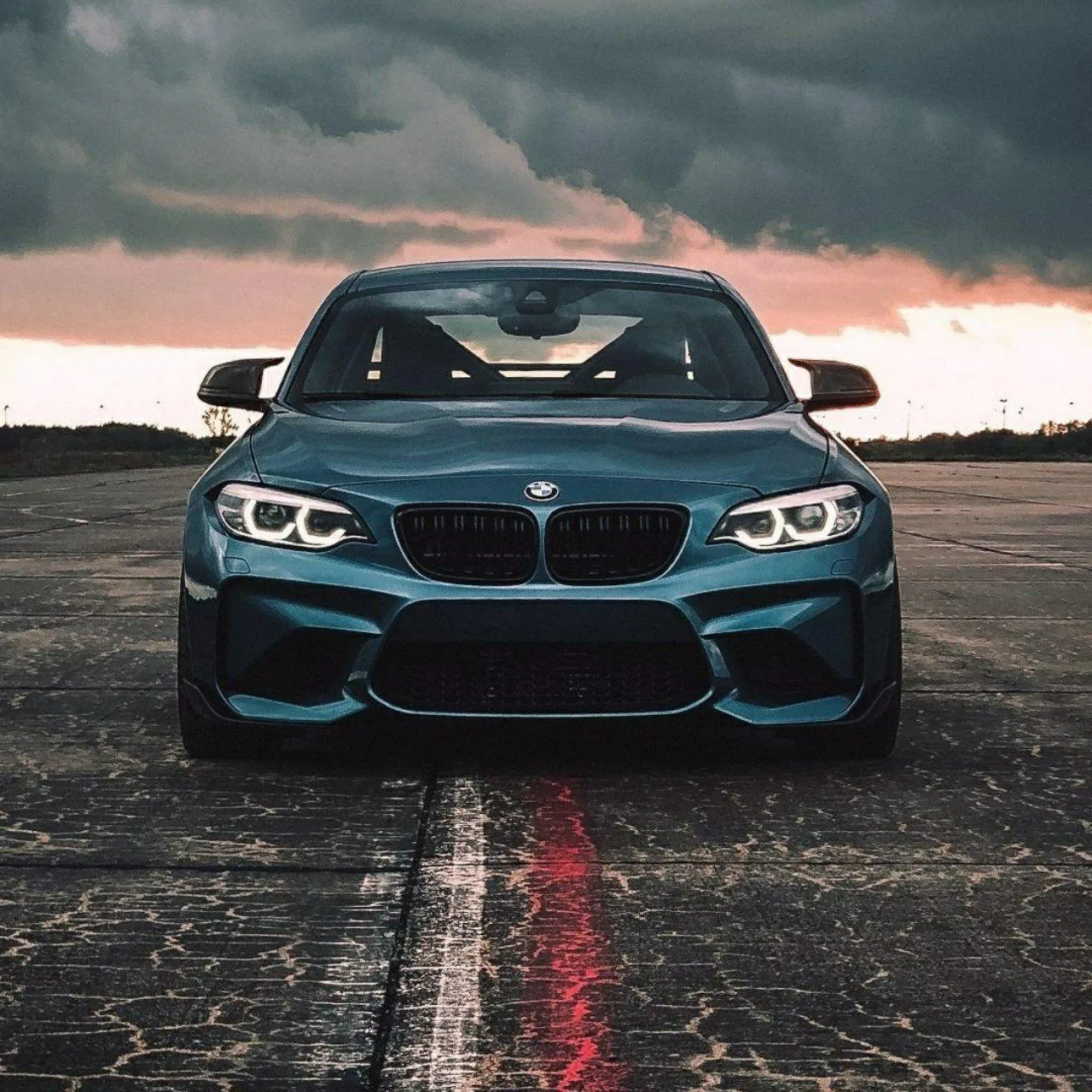 Teal Bmw M Car on Runway with Red and White Lines Wallpaper