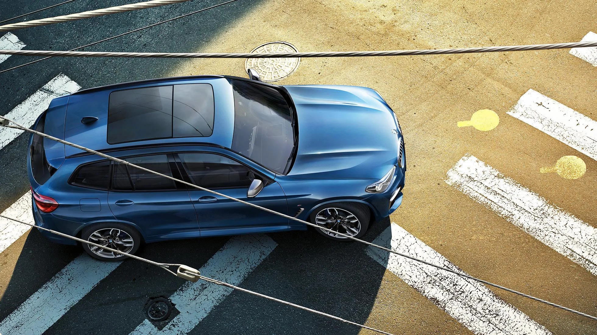 Top View of Blue Bmw on Curved City Road with Shadows