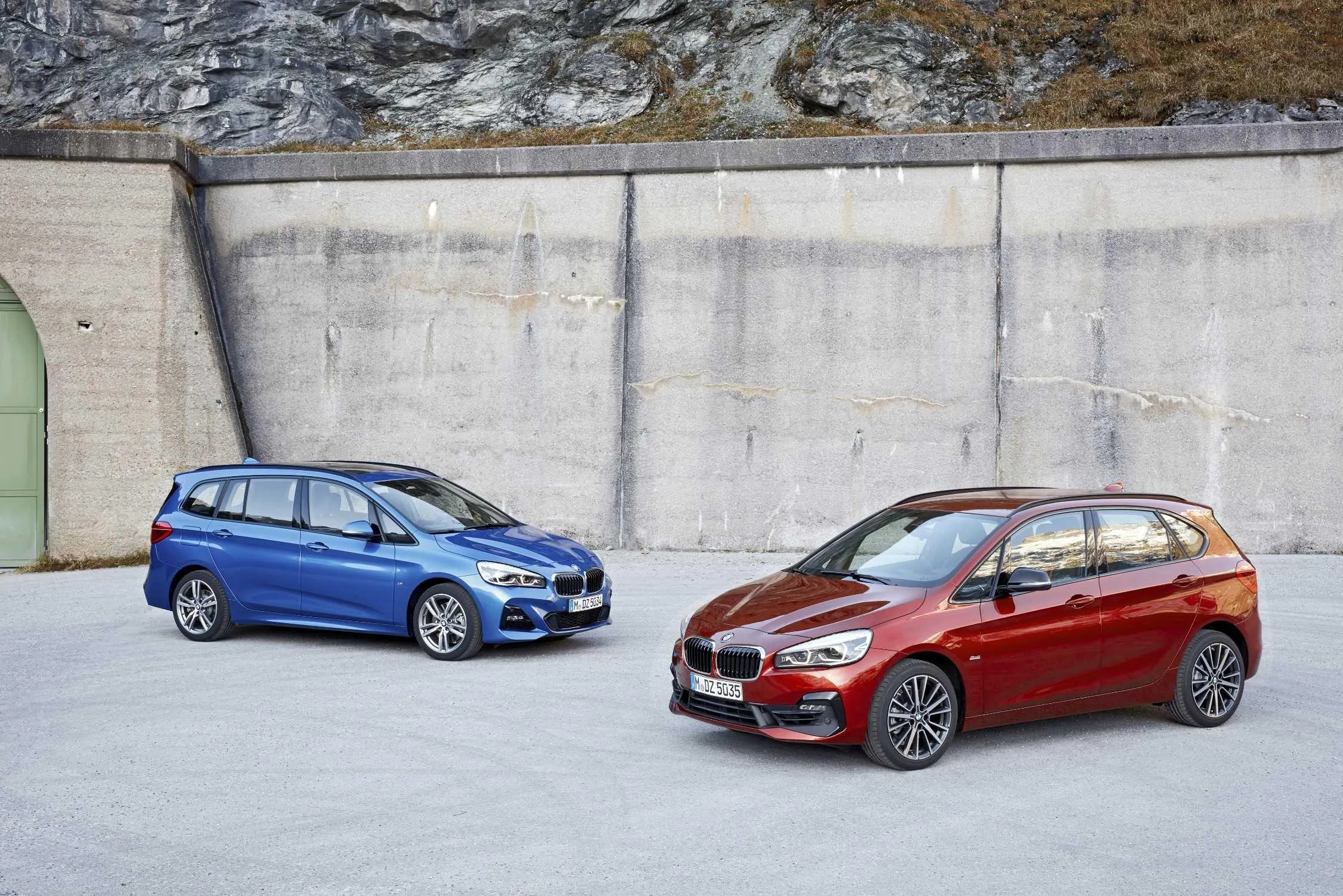 Two Bmw Cars Parked Near Concrete Wall on Mountain Road