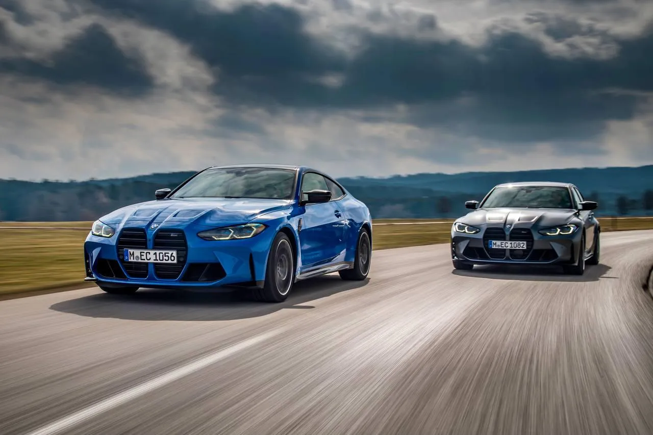 Two Bmw Cars Racing Side By Side on a Wide Open Road
