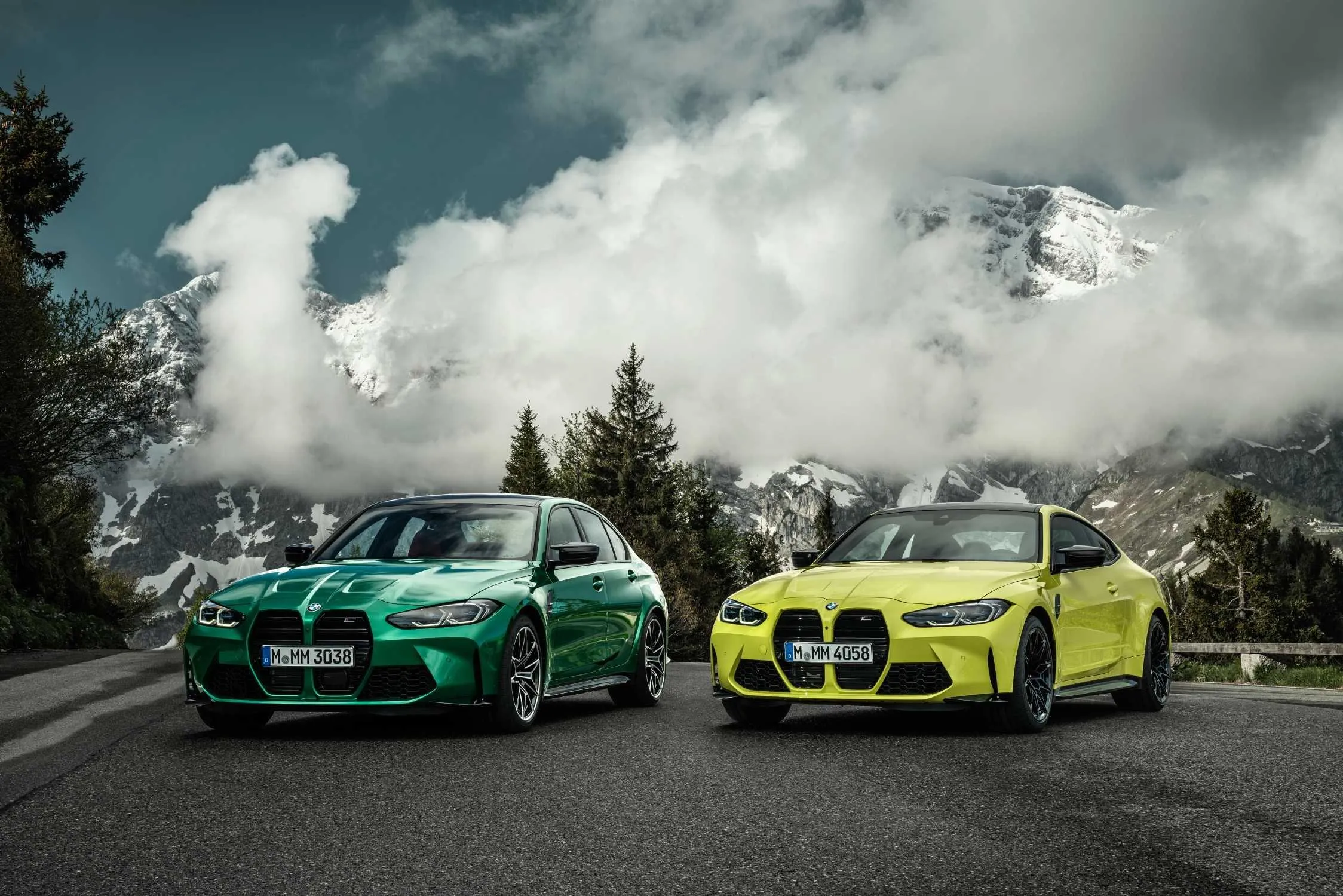 Two Bmw Sports Cars Parked with Mountains Behind Image