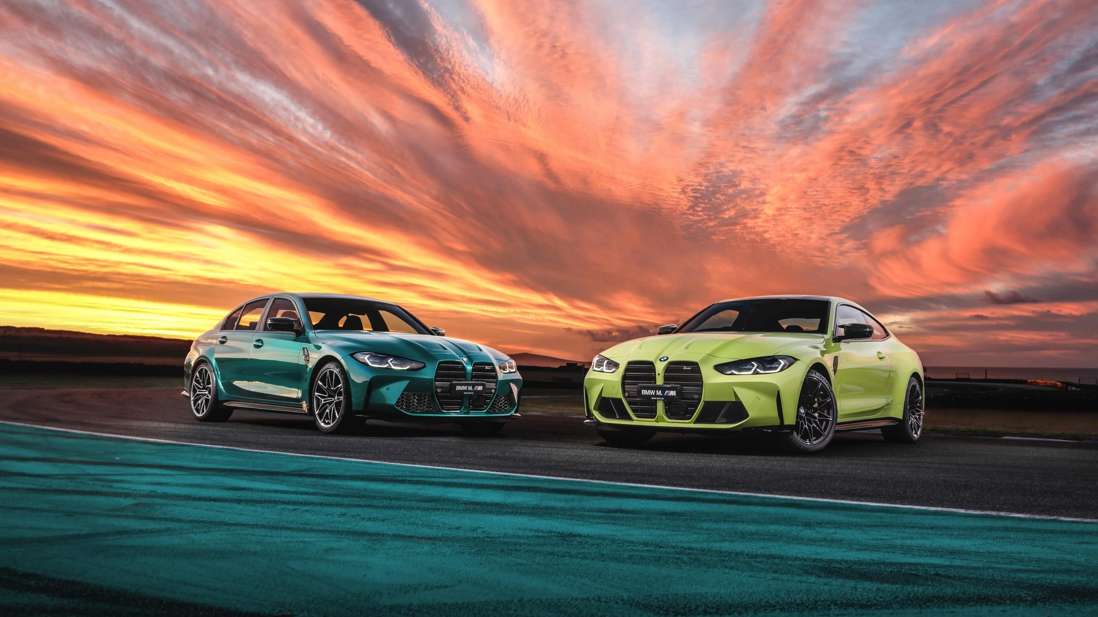 Two Bmws Racing Under Stunning Sunset Sky Scene Wallpaper