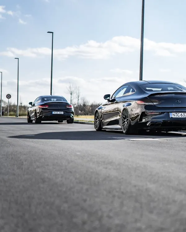 Two Mercedes Benz Sedans Parked on Sunny Street Wallpaper