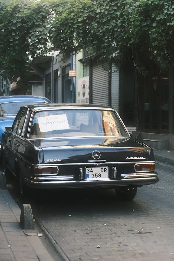 Vintage black Mercedes parked on narrow quiet road image