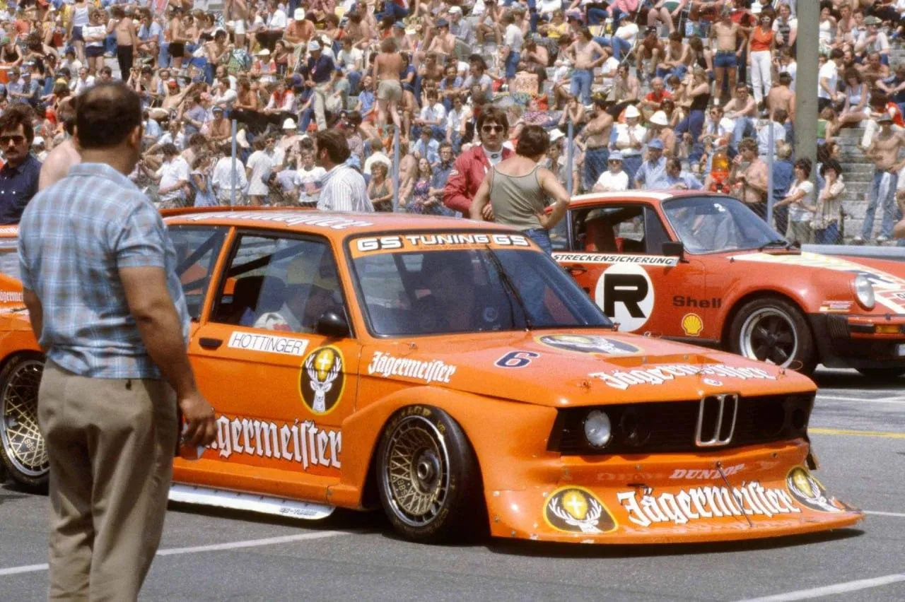 Vintage Bmw Race Car Competing in Front of a Large Crowd