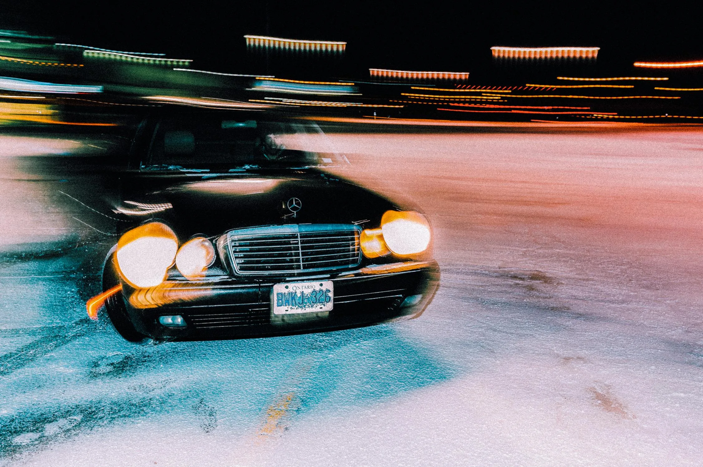 Vintage Mercedes in Motion on Icy Track with Blurred Lights