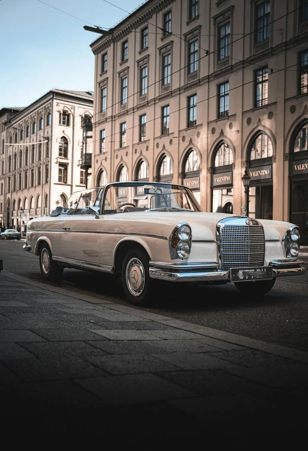 Vintage Mercedes Sedan Driving on Historic City Street