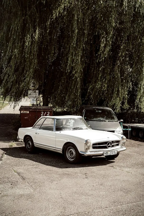 Vintage White Mercedes Benz Parked by Large Tree Wallpaper