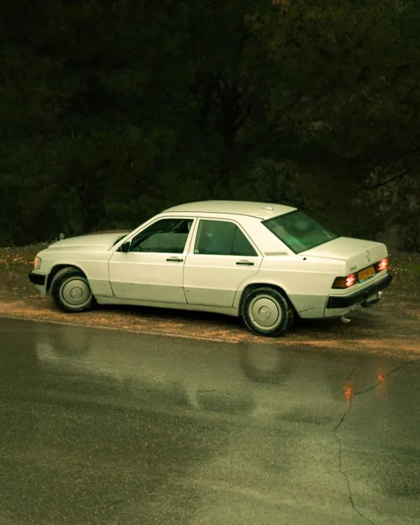 Vintage White Mercedes Parked on Wet Street in Rain image