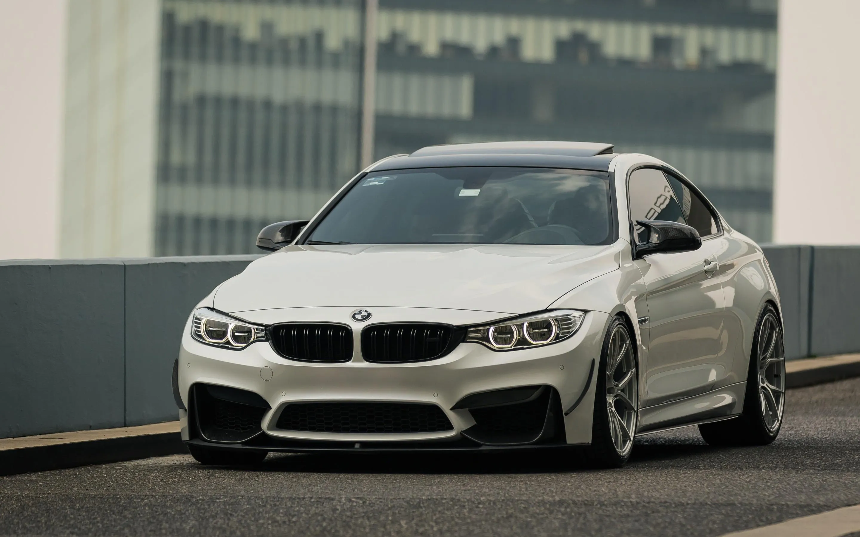 White Bmw Coupe Parked Near Glass Building in Soft Daylight