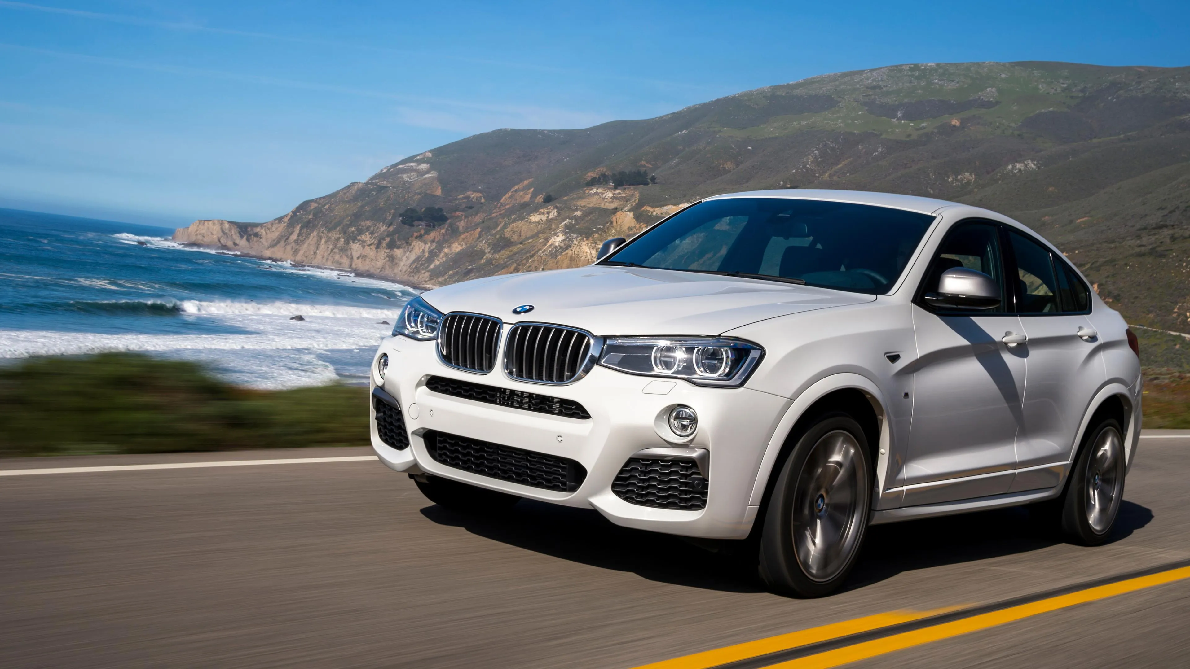 White Bmw Driving Near Coastal Mountain Highway Road