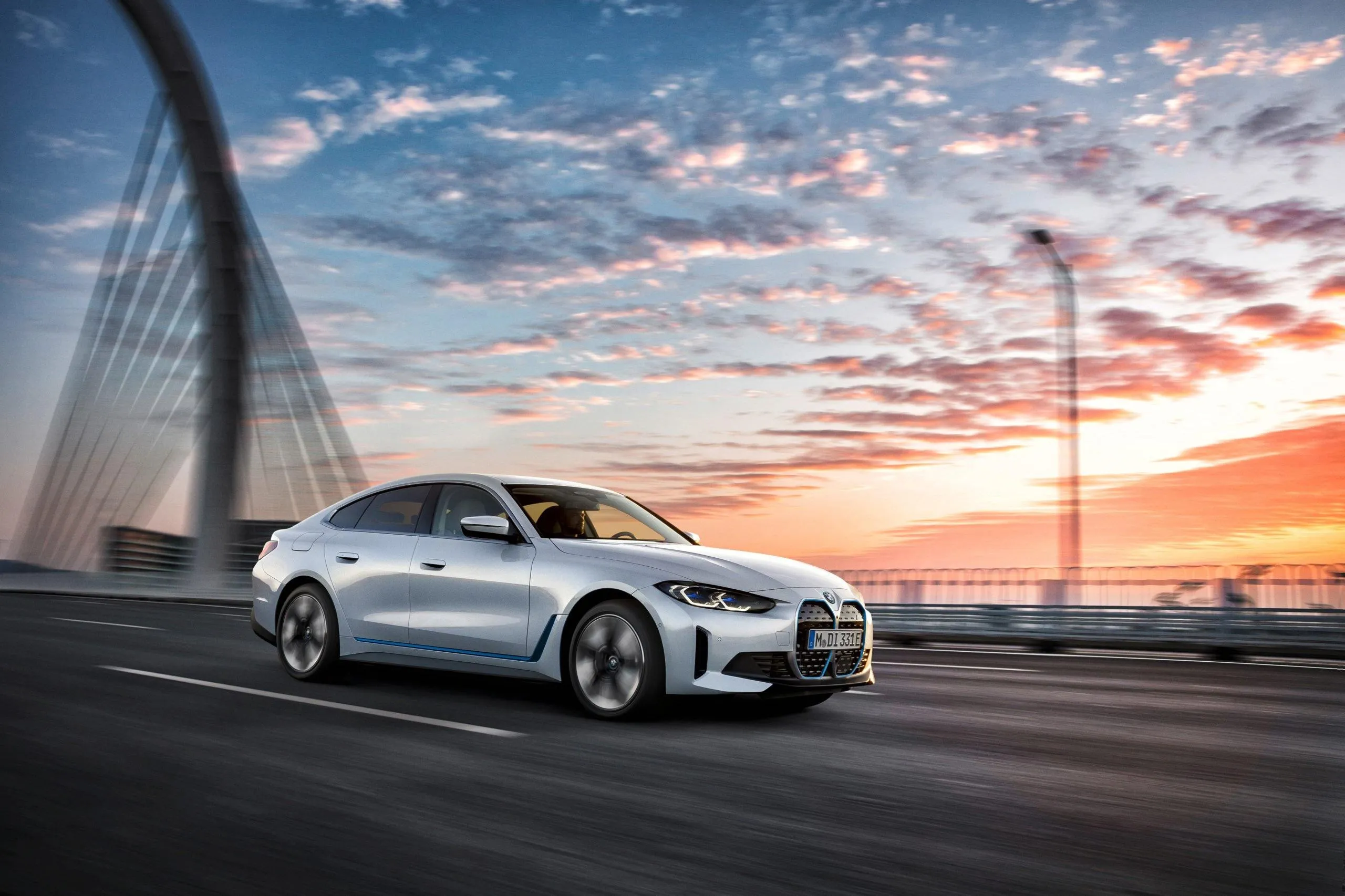 White Bmw Driving on a Bridge During a Bright Colorful Sunset