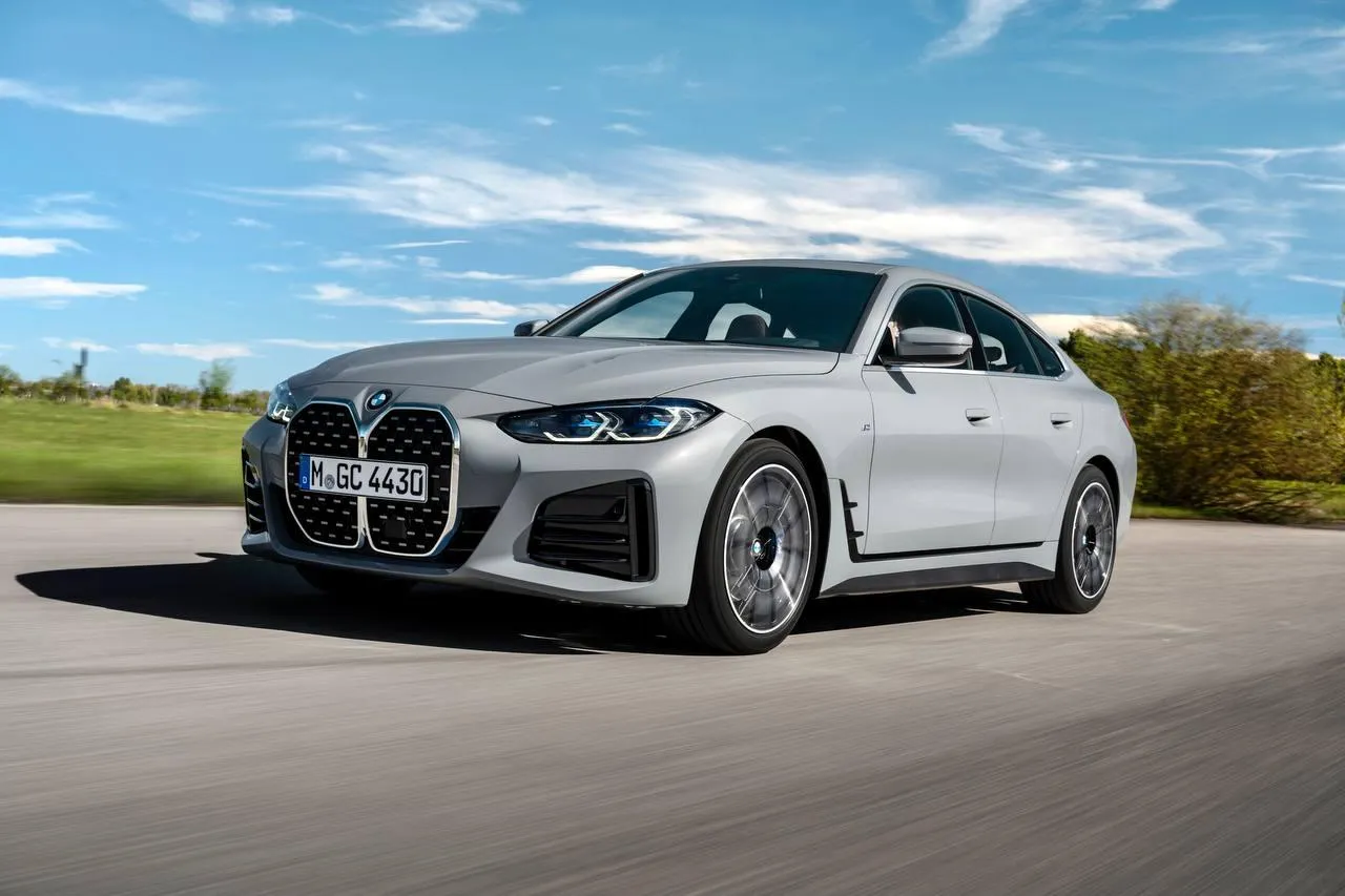 White Bmw Driving on Open Road Under Clear Blue Sky